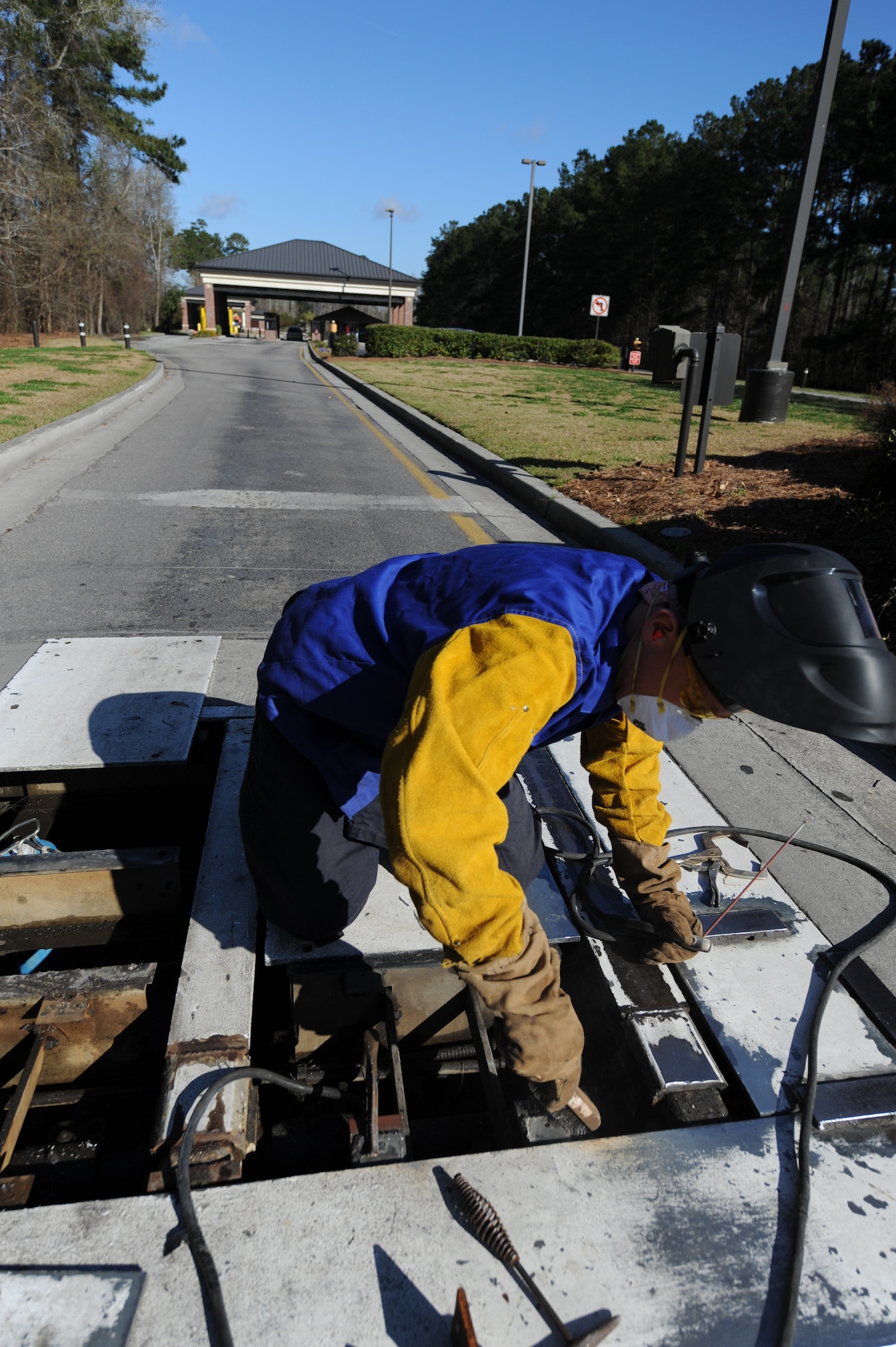 U.S. Air Force Master Sgt. Daniel Martin uses a wire brush to remove slag, which is the residue leftover after welding, from the pop-up security barrier at the inbound Rivers Avenue gate entrance on Joint Base Charleston, S.C., March 23, 2010. Sergeant Martin was at the gate to weld more steel to the barrier for reinforcement. Sergeant Martin is the NCO in charge of the structure shop with 628th Civil Engineer Squadron. (U.S. Air Force photo/James Bowman/released)
