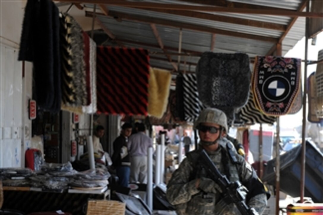 A U.S. Army soldier with Red Platoon, Combined Security Force passes shops during an Operation Broadway Cruiser patrol in Kirkuk, Iraq, on March 8, 2010.  The soldiers are maintaining a presence in the city while elections are taking place.  