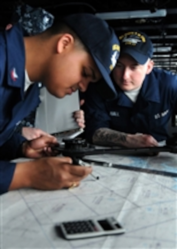 U.S. Navy Seaman Ryan P. Hall (right) watches Petty Officer 2nd Class Paulino Martinez chart a course aboard the aircraft carrier USS George H.W. Bush (CVN 77) while the ship is underway in the Atlantic Ocean on March 16, 2010.  The carrier is supporting fleet training operations.  