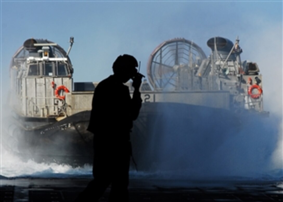 U.S. Navy Seaman Megan Arjoon directs a landing craft, air cushion from Assault Craft Unit 5 into the well deck of the forward-deployed amphibious dock landing ship USS Harpers Ferry (LSD 49) in Luzon, Philippines, on March 16, 2010.  