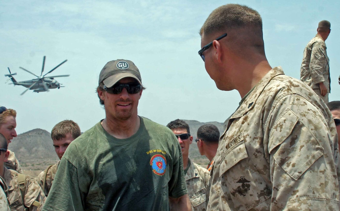 NFL players Drew Brees from the New Orleans Saints, Billy Miller from the New Orleans Saints, and Donnie Edwards from the Kansas City Chiefs visit Marines from 24th Marine Expeditionary Unit in Djibouti, Africa as part of a USO tour March 29, 2010.  Marines had a chance to get autographs, and show the players some of the training the Marines have been participating in while in Djibouti.  Players also had a chance to get some hands on training from some of the Marines.  Marines and Sailors of the 24th MEU are conducting a series of sustainment and joint training exercises in Djibouti while deployed with the Nassau Amphibious Ready Group as the theater reserve for Central Command.   (U.S. Marine Corps photo by Gunnery Sgt James Frank)