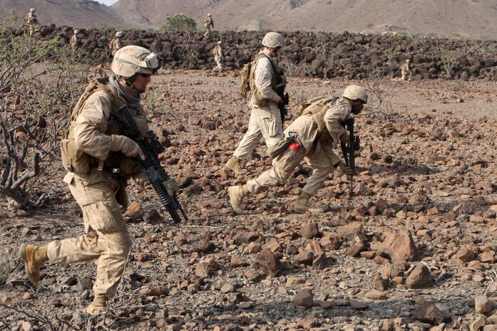 Cpl. Kyle Smith, team leader with 1st platoon, Alpha Company, Battalion Landing Team 1st Battalion, 9th Marine Regiment, 24th Marine Expeditionary Unit, advances his team through the rocky terrain during a mechanized assault as part of a live fire range in Djibouti, Africa March 29, 2010.  The infantry Marines initially closed with their objective riding through the mountainous, desert environment, in the back of Assault Amphibious Vehicles from the 24th MEU's Amphibious Assault Vehicle platoon.  24th MEU Marines performed a series of sustainment exercises, as well as bi-lateral training alongside the French military, during a month-long rotation of units from 24th MEU conducting training in the east-African country.  The 24th MEU currently serves as the theatre reserve force for Central Command.  (U.S. Marine Corps photo by Sgt. Alex Sauceda)