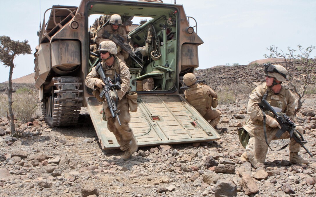 Cpl. Daniel Mallory, a squad leader with 1st platoon, Alpha Company, Battalion Landing Team 1st Battalion, 9th Marine Regiment, 24th Marine Expeditionary Unit, posts security at  the rear of an assault amphibious vehicle (AAV) as team leader Lance Cpl. Daniel Pursley, exits towards their objective point during a mechanized assault as part of a live fire range in Djibouti, Africa, March 29.  The infantry Marines initially closed with their objective riding through the mountainous, desert environment, in the back of Assault Amphibious Vehicles from the 24th MEU's Amphibious Assault Vehicle platoon.  24th MEU Marines performed a series of sustainment exercises, as well as bi-lateral training alongside the French military, during a month-long rotation of units from 24th MEU conducting training in the east-African country.  The 24th MEU currently serves as the theatre reserve force for Central Command.  (U.S. Marine Corps photo by Sgt. Alex Sauceda)