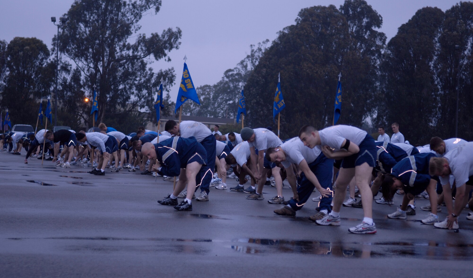 VANDENBERG AIR FORCE BASE, Calif. -- Preparing for the three-mile April Awareness Month Kick-off Run, Team V stretches here Tuesday, March 30, 2010. Other than the typical physical training uniform, the participants were authorized to wear blue T-shirts in support of Child Abuse Prevention Month or teal T-shirts in support of Sexual Assault Awareness Month. (U.S. Air Force photo/Airman 1st Class Lael Huss) 