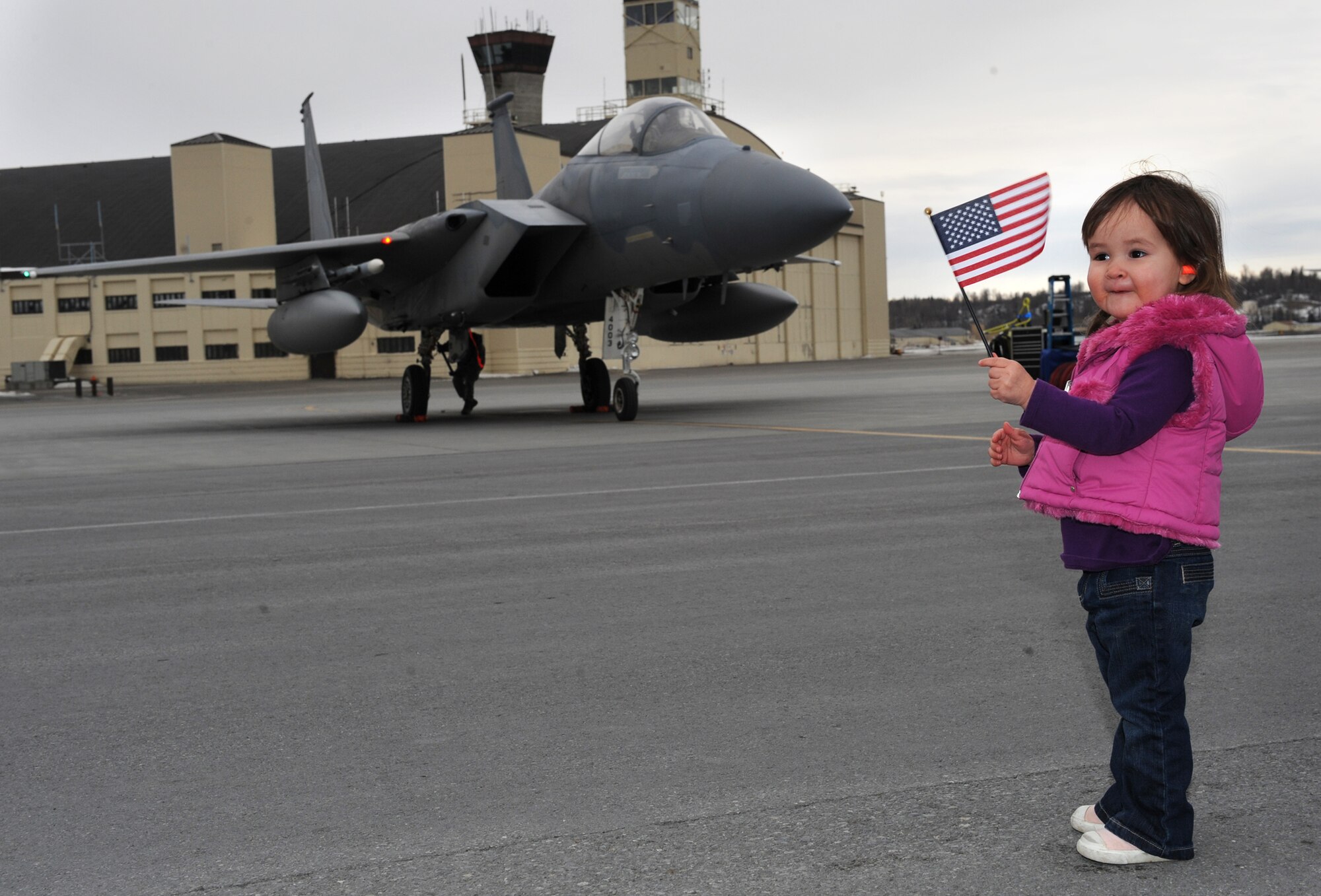 ELMENDORF AIR FORCE BASE, Alaska –Milla Typolt, 2, waves the American Flag while waiting for her father Capt. Ryan Typolt, 19th Fighter Squadron pilot, to taxi in place March 29. The 19th FS returned from their last temporary duty assignment as a squadron here at Elmendorf. (Air Force photo by Senior Airman Cynthia Spalding)
