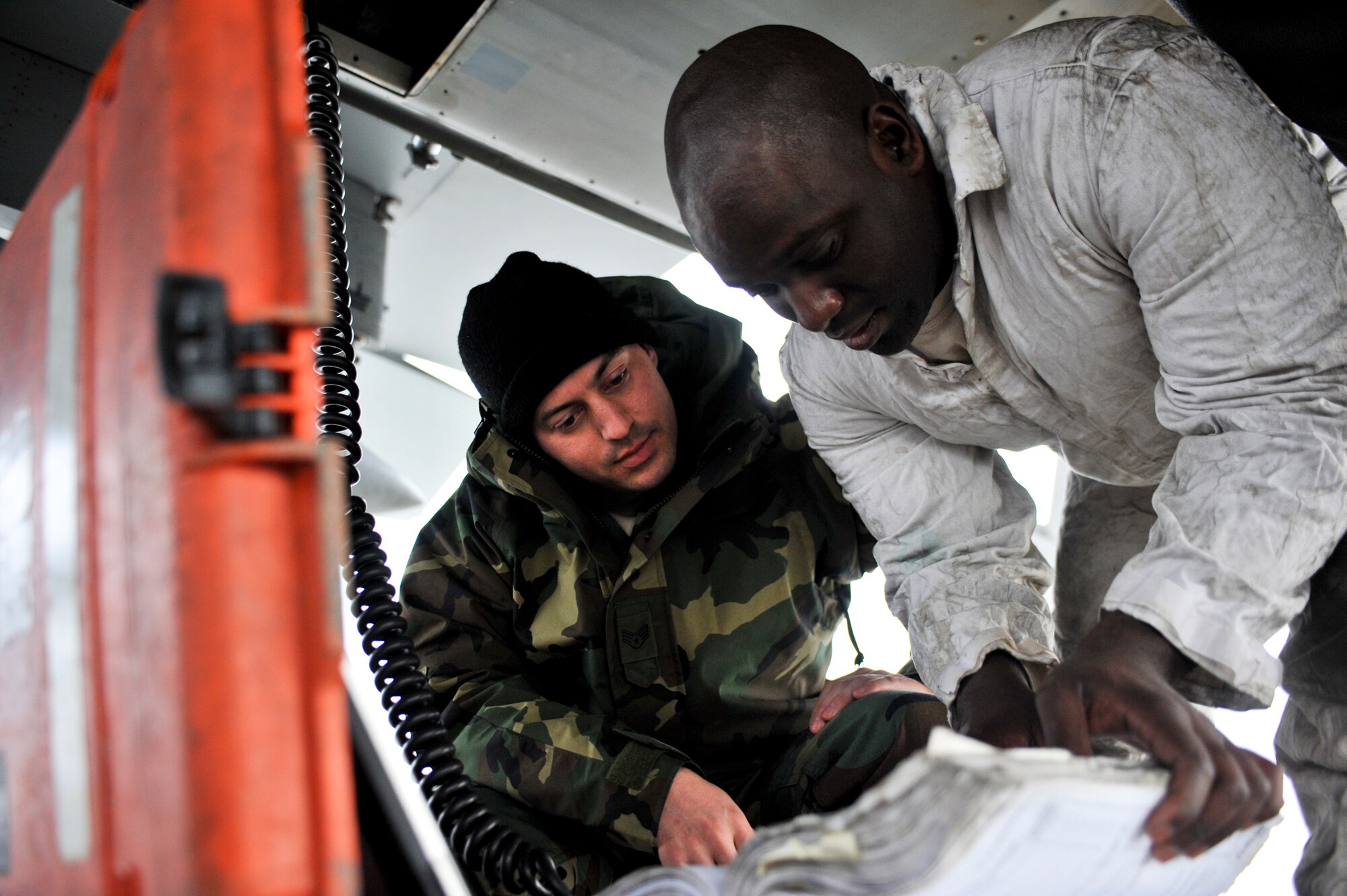 ELMENDORF AIR FORCE BASE, Alaska -- Staff Sgt. Emilo Gordon, 3rd Aircraft Maintenance Squadron, works together with Staff Sgt. Jason Morris, 19th Aircraft Maintenance Unit, underneath one of the recently returned F-15 Eagles March 29 . Elmendorf’s 19th Fighter Squadron is soon to be decommissioned with the first F-15s leaving in April 2010 and the final few scheduled to leave in September 2010. Some of the jets returned from more than a month-long temporary duty assignment. Four jets from the 19th Fighter Squadron participated in Thailand’s exercise Cope Tiger from Feb. 26-March 13. After departing Thailand, they flew to Kadena Air Base where they rested for two days and flew out March 15 to meet up with four other Elmendorf F-15s, that participated in Cope Thaw in Hawaii.  (Air Force photo by Airman 1st Class Christopher Gross)