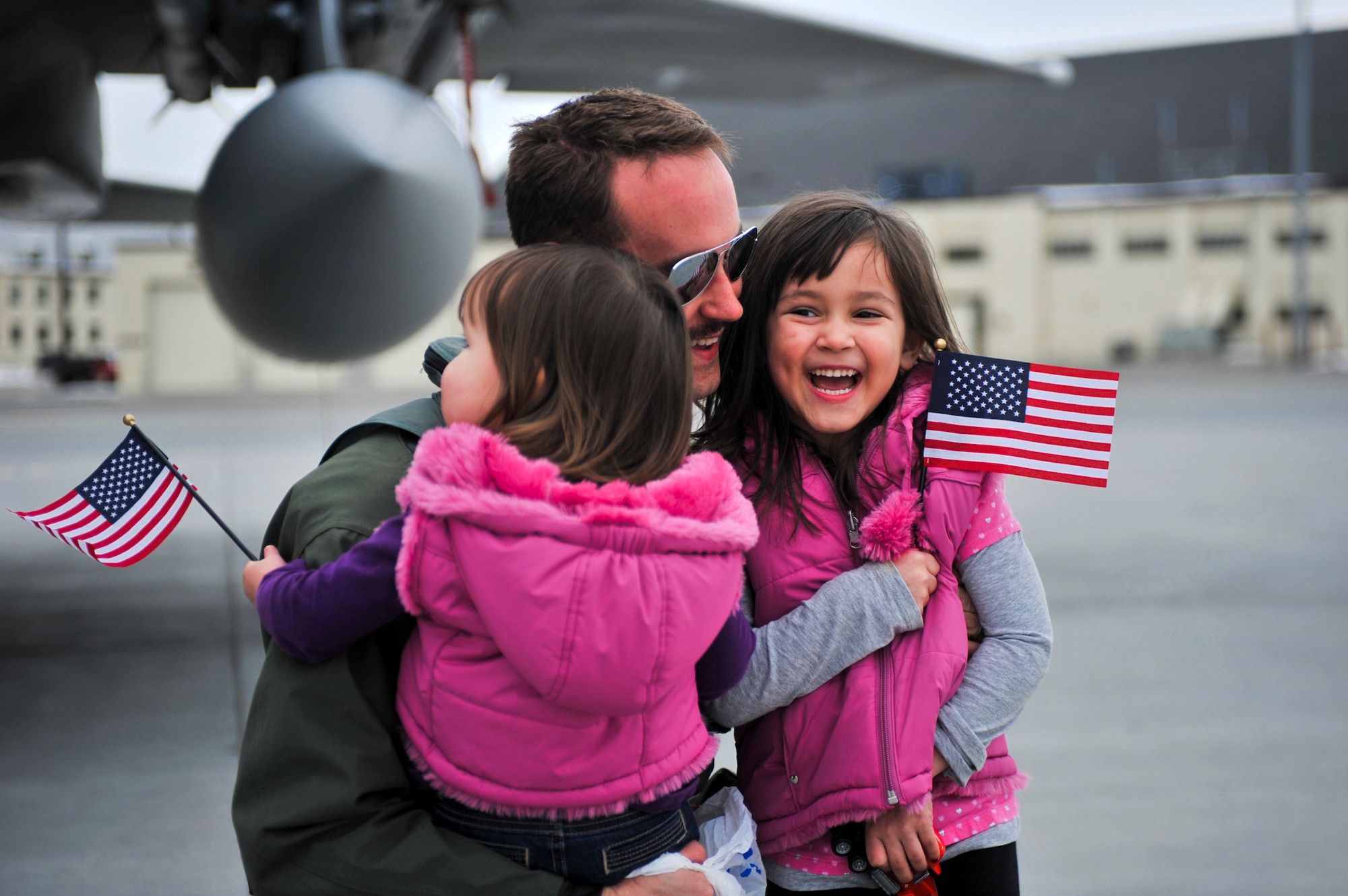 ELMENDORF AIR FORCE BASE, Alaska – Capt. Ryan Typolt embraces his daughters Selah, 5, and Milla, 2, after arriving from a temporary duty assignment. Elmendorf’s 19th Fighter Squadron is soon to be decommissioned with the first F-15s leaving in April 2010 and the final few scheduled to leave in September 2010. Some of the jets returned from more than a month-long TDY. Four jets from the 19th Fighter Squadron participated in Thailand’s exercise Cope Tiger from Feb. 26-March 13. After departing Thailand, they flew to Kadena Air Base where they rested for two days and flew out March 15 to meet up with four other Elmendorf F-15s, that participated in Cope Thaw in Hawaii. (Air Force photo by Airman 1st Class Christopher Gross)