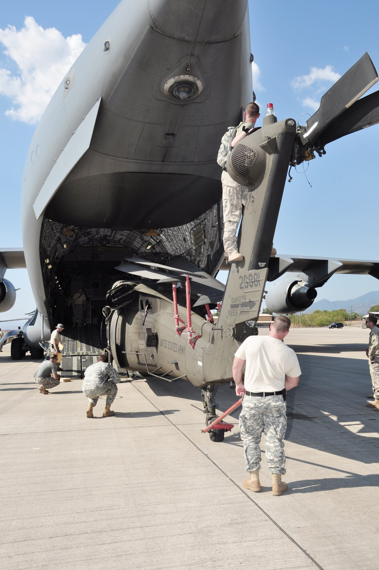 Joint Task Force-Bravo members load a C-17 Globemaster III March 20 with the first of three UH-60 Blackhawks that were loaded in a single aircraft March 20, 2010, at Soto Cano Air Base, Honduras. Soto Cano AB officials sent more than 180,000 pounds of equipment and 40 servicemembers to support Joint Task Force-Haiti's disaster relief mission, Operation Unified Response. (U.S. Air Force photo/Staff Sgt. Bryan Franks)