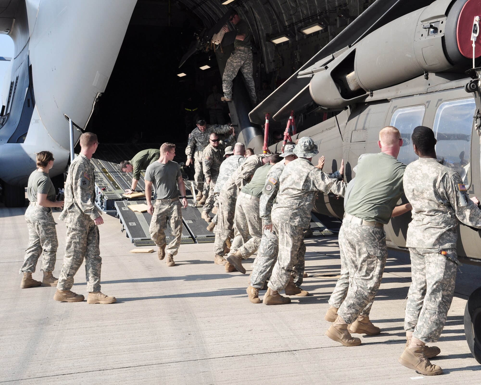 Joint Task Force-Bravo members keep a UH-60 Blackhawk straight while loading it onto a C-17 Globemaster III March 20, 2010, at Soto Cano Air Base, Honduras. Soto Cano AB officials sent 40 servicemembers and four UH-60 Blackhawks to support Joint Task Force-Haiti airlift operations as part of the disaster relief mission Operation Unified Response. (U.S. Air Force photo/Staff Sgt. Bryan Franks)