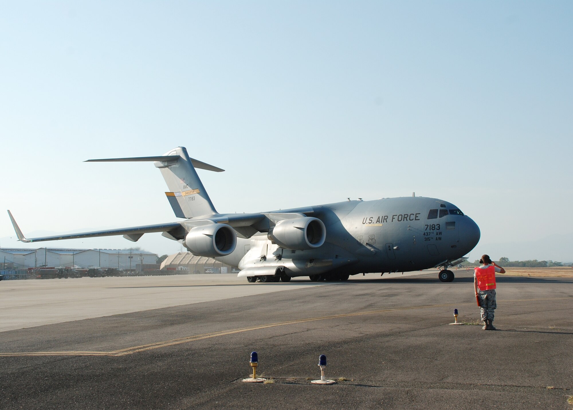 Senior Airman Kristopher Rainwater salutes a C-17 Globemaster III as it departs March 21, 2010, from Soto Cano Air Base, Honduras, with Joint Task Force-Bravo members deploying to Port au Prince, Haiti. Soto Cano AB officials sent 40 servicemembers and four UH-60 Blackhawks to support Joint Task Force-Haiti airlift operations as part of the disaster relief mission Operation Unified Response. Airman Rainwater is a 612th Logistics Readiness Squadron crew chief. (U.S. Air Force photo/1st Lt. Jen Richard)