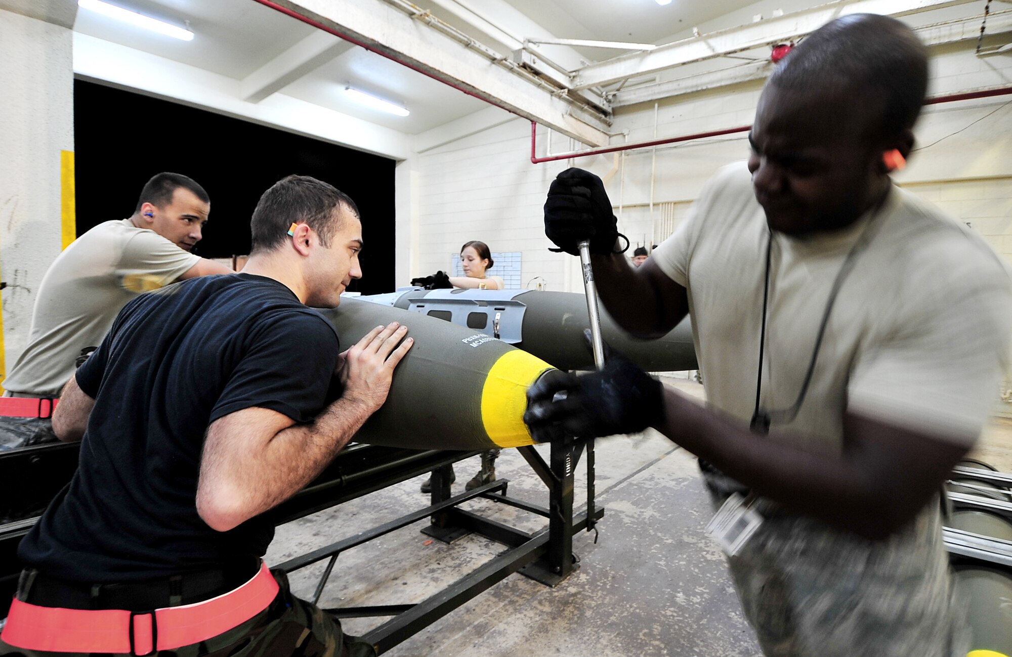 Airmen from the 18th Munitions Squadron build Mark-83 bomb bodies during a base exercise March 24, 2010, at Kadena Air Base, Japan. The 18th Wing participated in a local operational readiness exercise to test base Airmen's ability to defend Japan and maintain peace and stability in the Pacific region. (U.S. Air Force photo/Tech. Sgt. Rey Ramon)