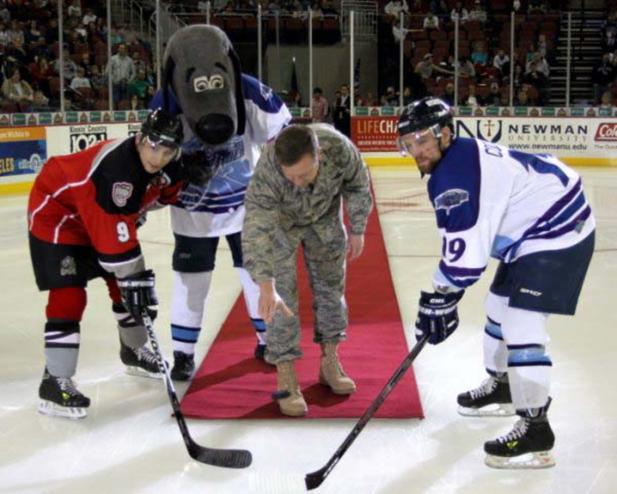 Col. Edsel "Archie" Frye, 931st Air Refueling Group commander, with encouragement from the Wichita Thunder mascot "Thunderdog", drops the ceremonial puck as Amarillo Gorilla center Gordon Bell-left, and Wichita Thunder alternate captain Kevin Cooper prepare to duel for the opening possession betwen the two teams on March 12 . The Air Force Reserve Central Recruiting Squadron recently sponsored multiple events with the Wichita Thunder. The Gorillas revenged a loss from the previous night by defeating the Thunder 6-0.