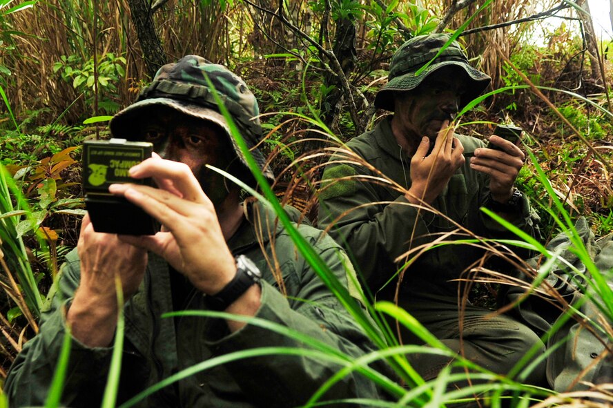 Capt. Aaron Wallace (left) and 1st Lt. Joseph Bisson apply camouflage during an evasion scenario after a simulated KC-135 crash at Kadena Air Base, Japan, March 25, 2010. The 18th Wing participated in a local operational readiness exercise March 22 through 26 to test base Airmen's ability to defend Japan and maintain peace and stability in the Pacific region. Captain Wallace and Lieutenant Bisson are both pilots from the 909th Air Refueling Squadron. (U.S. Air Force photo/Senior Airman Amanda N. Grabiec)