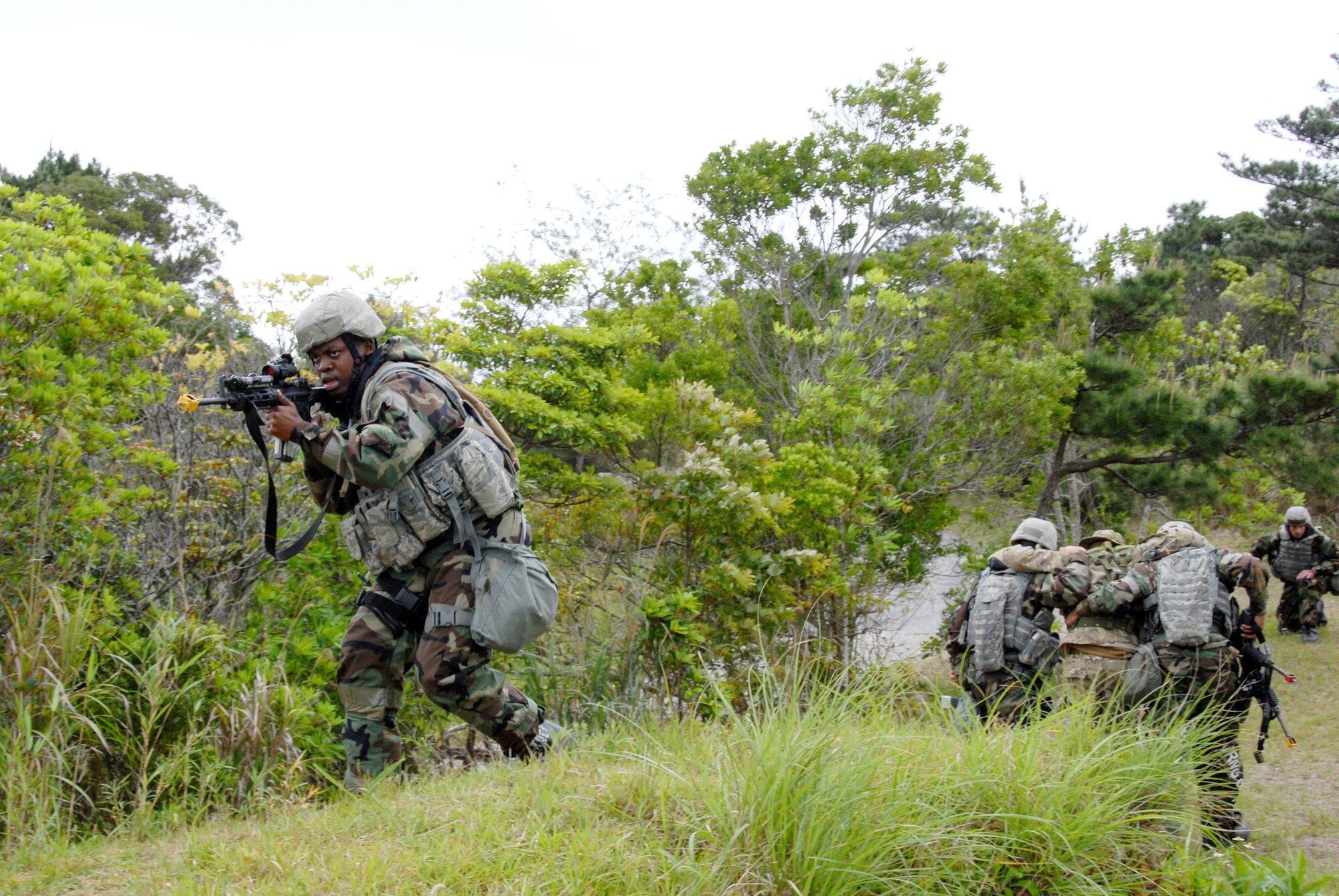 Airmen from the 18th Wing Security Forces Squadron come under simulated fire while on a combat patrol during a base exercise March 25, 2010, at Kadena Air Base, Japan. The 18th Wing participated in a local operational readiness exercise to test base Airmen's ability to defend Japan and maintain peace and stability in the Pacific region. (U.S. Air Force photo/Junko Kinjo)                   