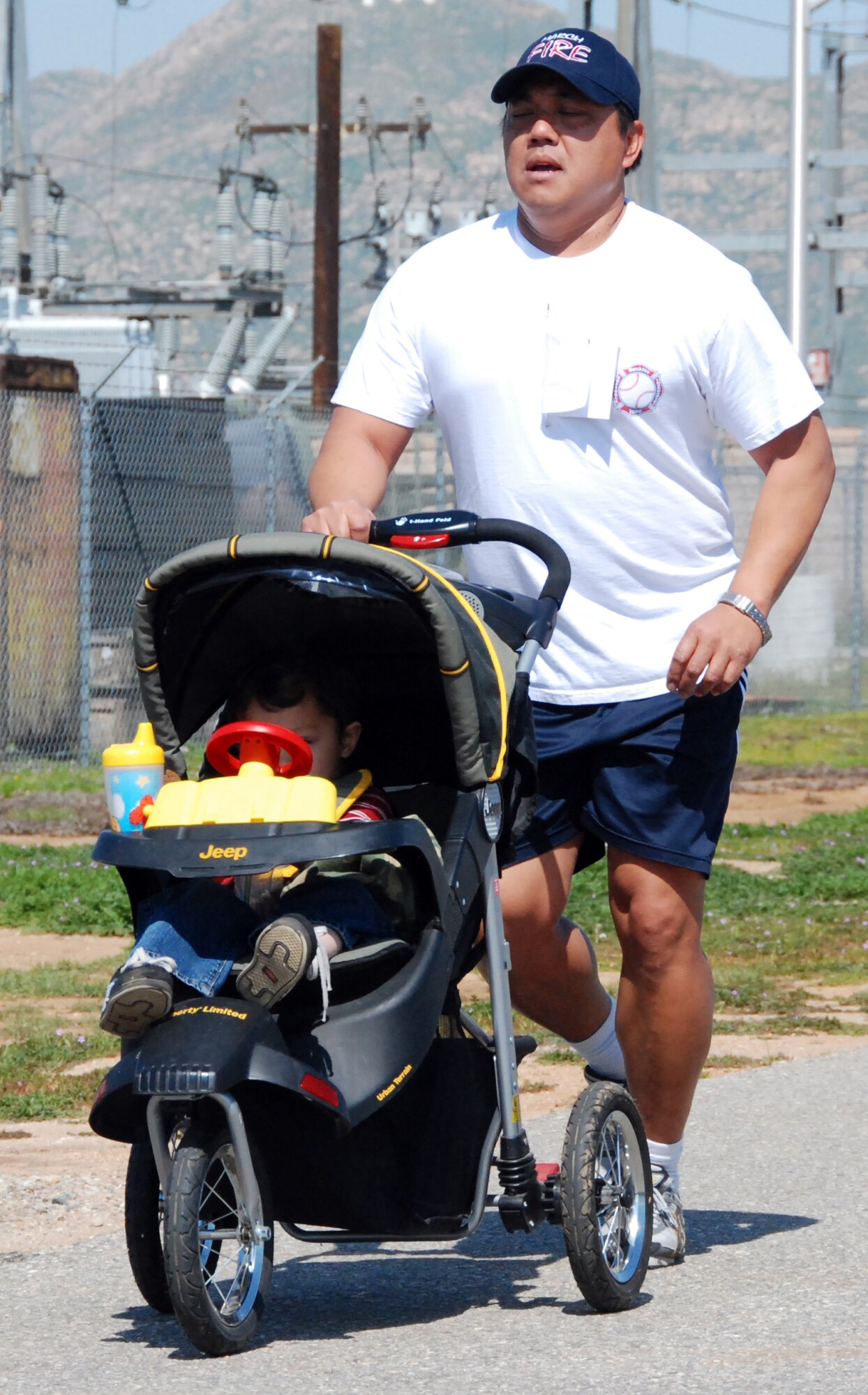 FATHER AND SON: Roderick Rambayon, a firefighter with the March ARB Fire Department jogs. His son helps by “driving” the stroller. (U.S. Air Force photo by Henry Kim)
