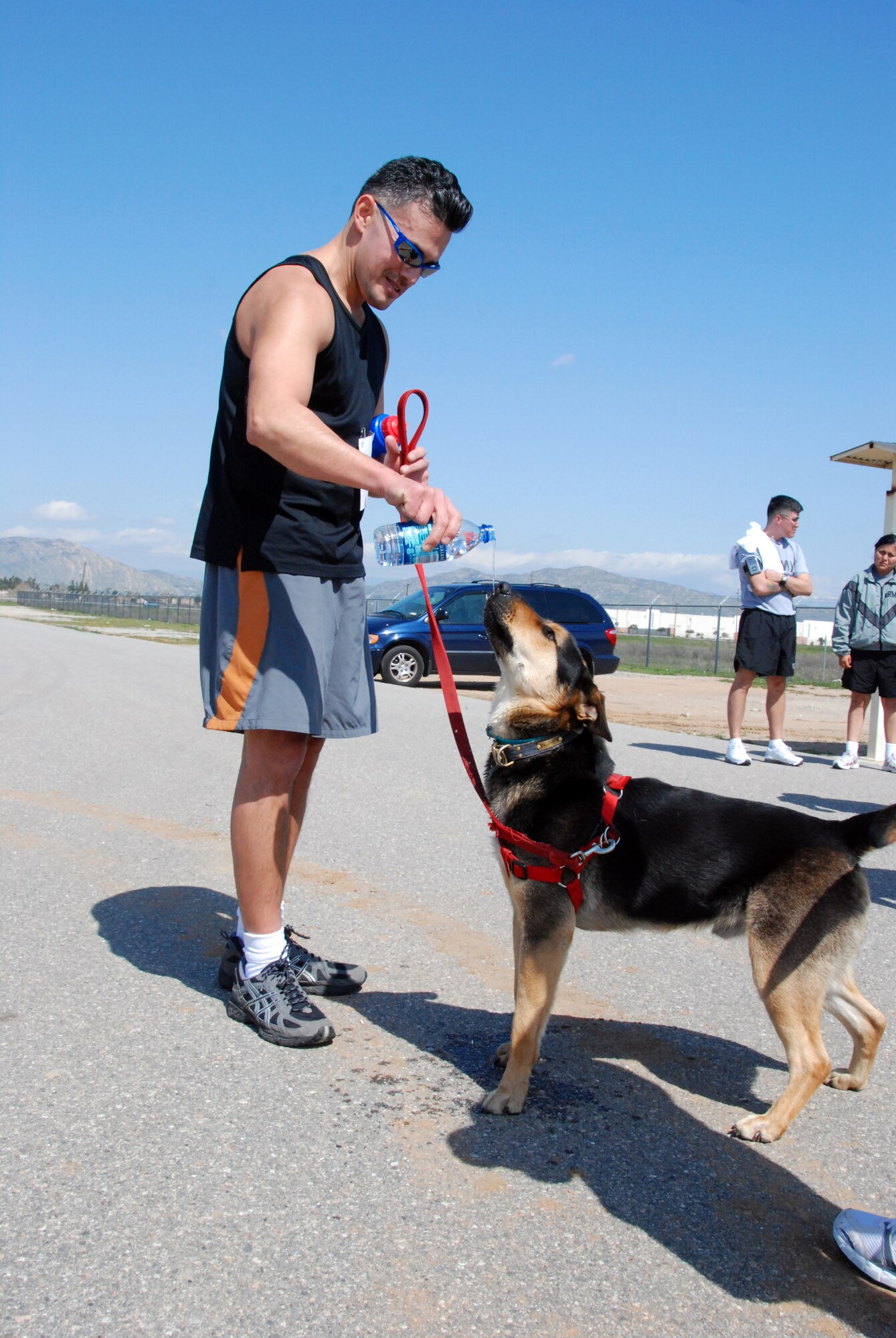 MAN AND BEST FRIEND: Tech. Sgt. Eduardo Ayala’s puppy joined him for the Wounded Warriors Run. After the race, he and the puppy shared a bottle of water. Sergeant Ayala is a member of the 56th Aerial Port Squadron. (U.S. Air Force photo by Henry Kim)
