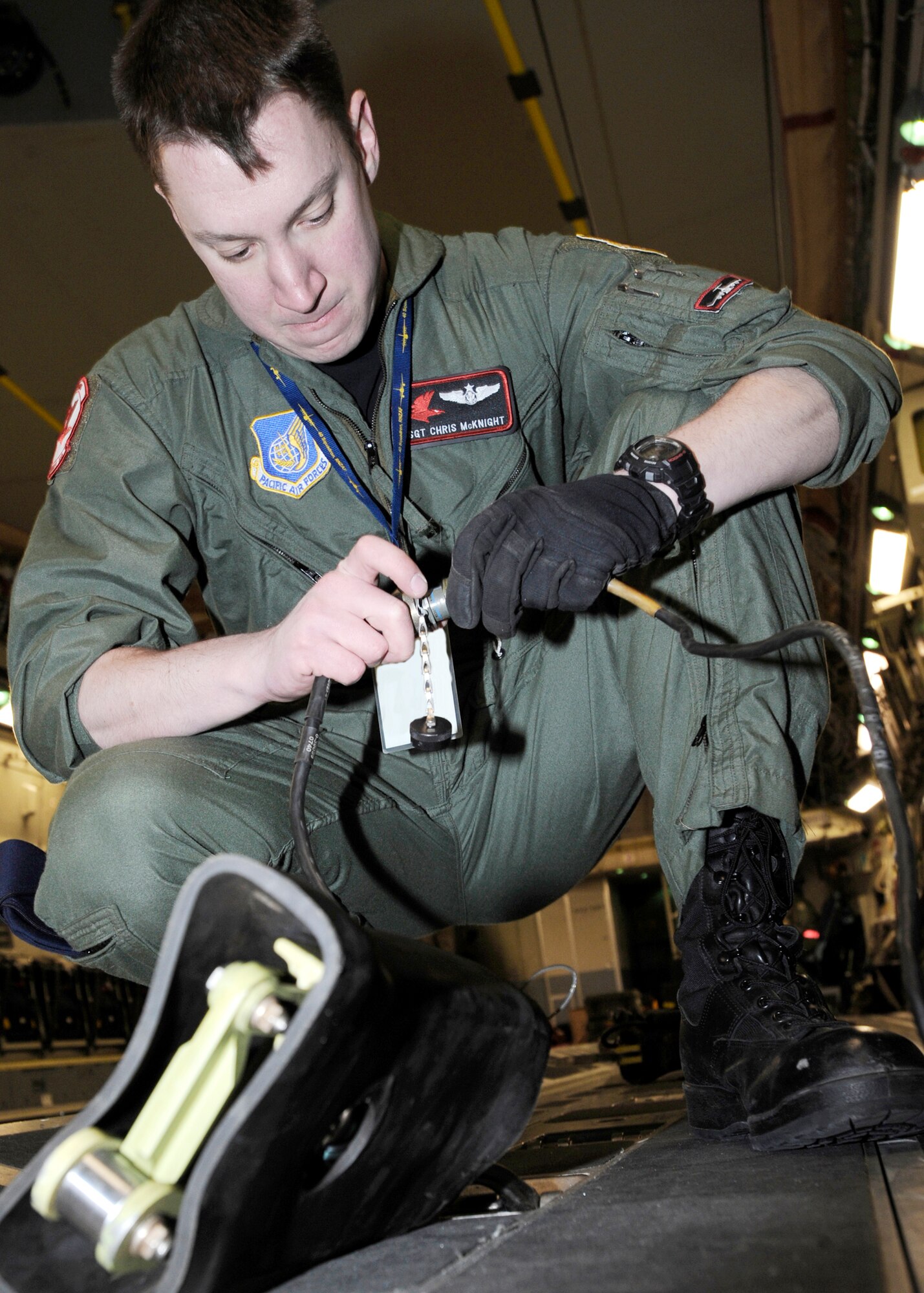 Staff Sgt. Chris McKnight prepares an electronic tie down before loading a crate onto a C-17 Globemaster III March 19, 2010, Elmendorf Air Force Base, Alaska. Sergeant McKnight and his crew from the 517th Airlift Squadron participated in a combat simulation improved container delivery drop over Tin City, Alaska. (U.S. Air Force photo/Senior Airman Matt Coleman-Foster)