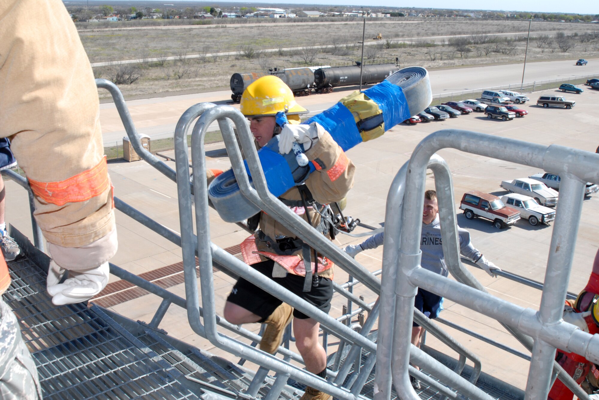GOODFELLOW AIR FORCE BASE, Texas -- A servicemember carries a 45-pound fire hose up five stories during the rookie firefighter challenge, March 27, 2010. The challenge is a competition in which teams and individuals are pushed to their physical limits doing various firefighting exercises and was open to everyone on base. (U.S. Air Force photo/Staff Sgt. Laura R. McFarlane)
