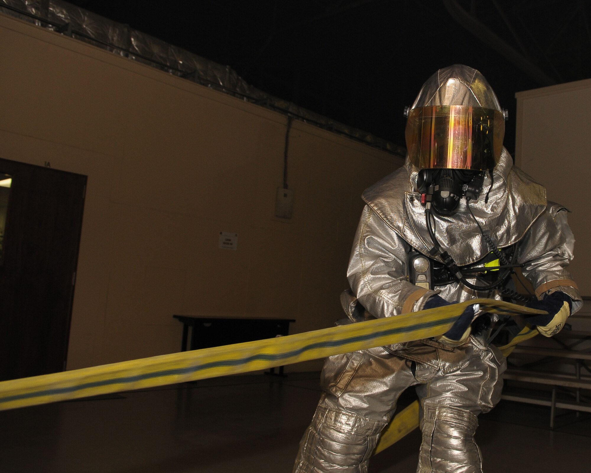 YOKOTA AIR BASE, Japan -- A firefighter assigned to the 374th Civil Engineer Squadron, unrolls a hose to extinguish a fire during an operational readiness exercise here Mar. 30.  The exercise tested Yokota Airmen's operational readiness preparedness. (U.S. Air Force photo/Airman 1st Class Sean Martin)