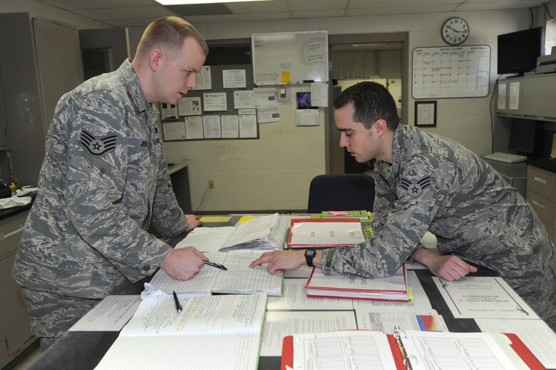 WHITEMAN AIR FORCE BASE, Mo. - Staff Sgt. Jason Jenkins and Senior Airman Ryan Bombardiere, 509th Civil Engineer Squadron water treatment plant operators, discuss their findings during the 10 a.m. water testing to figure out what chemicals are introduced into the water, March 29, 2010. These handwritten records document more than 340 water quality tests every 24 hours and who completed those individual tests.(U.S. Air Force photo/ Airman 1st Class Carlin Leslie)  (Released)
