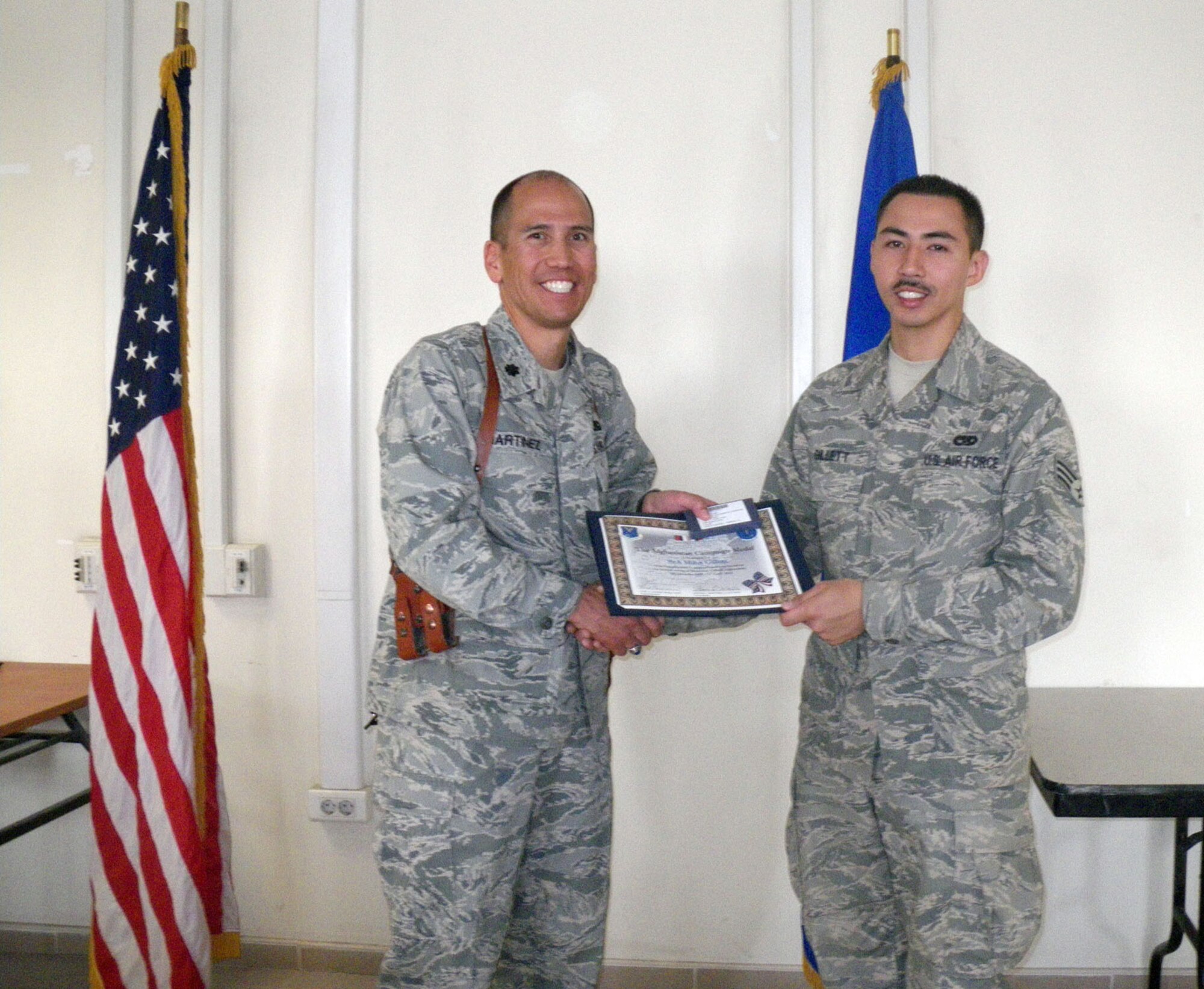 Kandahar, Afghanistan:  During the March Commander’s Call at the 451st Expeditionary Logistics Readiness Squadron, Tech. Sgt Robert A. Zumel and Senior Airman Minh L. Gillett both received the Afghanistan Campaign Medal from Lt. Col. Steve Martinez, Commander, 451st Expeditionary Logistics Readiness Squadron. In addition to the awards, Senior Airman Gillett also nabbed the coveted Airman of the month award and received a letter of appreciation. Just last month, Master Sgt. Khalid I. Ali received the NCO of the month award. Members of the 45th Aerial Port Squadron, Travis Air Force Base, Calif. are deployed to Kandahar Airfield, Afghanistan in support of Operation Enduring Freedom. (U.S. Air Force photo/Master Sgt. Stanley A. Bembo) 