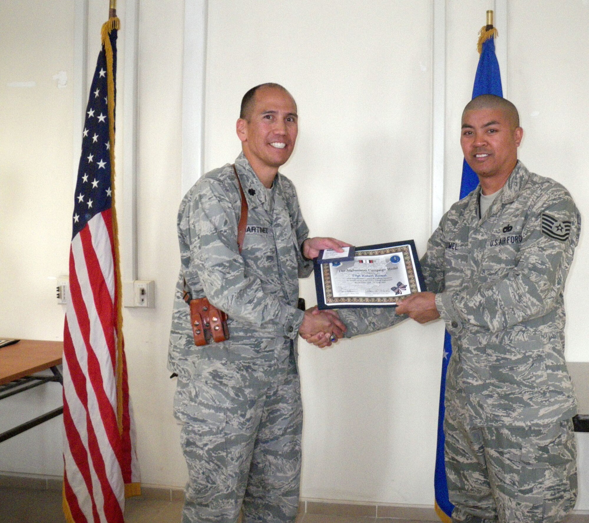 Kandahar, Afghanistan:  During the March Commander’s Call at the 451st Expeditionary Logistics Readiness Squadron, Tech. Sgt Robert A. Zumel and Senior Airman Minh L. Gillett both received the Afghanistan Campaign Medal from Lt. Col. Steve Martinez, Commander, 451st Expeditionary Logistics Readiness Squadron. In addition to the awards, Senior Airman Gillett also nabbed the coveted Airman of the month award and received a letter of appreciation. Just last month, Master Sgt. Khalid I. Ali received the NCO of the month award. Members of the 45th Aerial Port Squadron, Travis Air Force Base, Calif. are deployed to Kandahar Airfield, Afghanistan in support of Operation Enduring Freedom. (U.S. Air Force photo/Master Sgt. Stanley A. Bembo) 