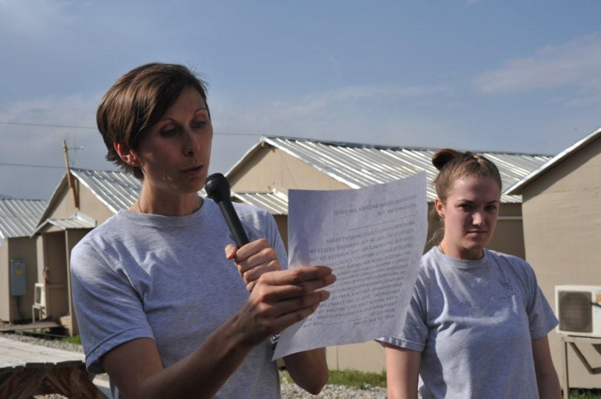 U.S. Air Force Tech. Sgt. Deborah Sheppard and Airman 1st Class Tiffany Hannan, 455th Expeditionary Medical Group/Task Force Medical, Team Life Saver, perform a radio script at the American Forces Network radio station during The Amazing Race Afghanistan sponsored by the 455th Expeditionary Force Support Squadron morale, welfare and recreation office, March 28, 2010. (U.S. Navy photo by/ Petty Officer 3rd Class Octavio Ortiz)