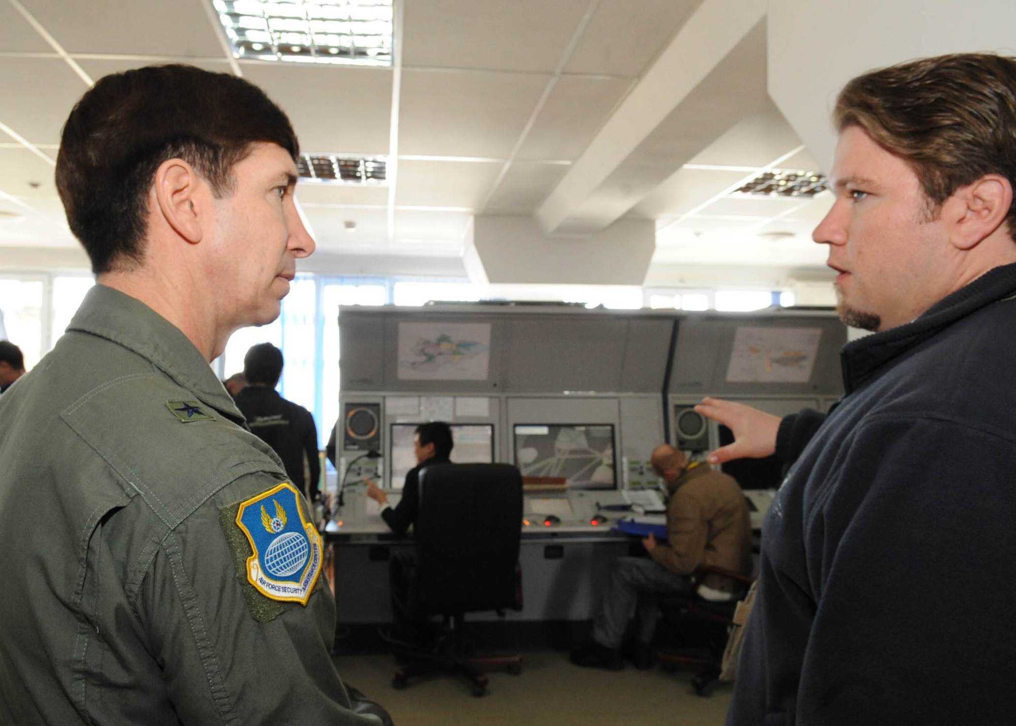 Luis Soares, 376th Air Expeditionary Wing contractor, speaks with Brig. Gen. Joseph A. Lanni, Commander, Air Force Security Assistance Center about the air traffic control procedures with the military and international airliners flying in and out of Manas International Airport during a site visit to the Transit Center at Manas, Kyrgyzstan, March 28, 2010. (U.S. Air Force photo/Senior Airman Nichelle Anderson/released)