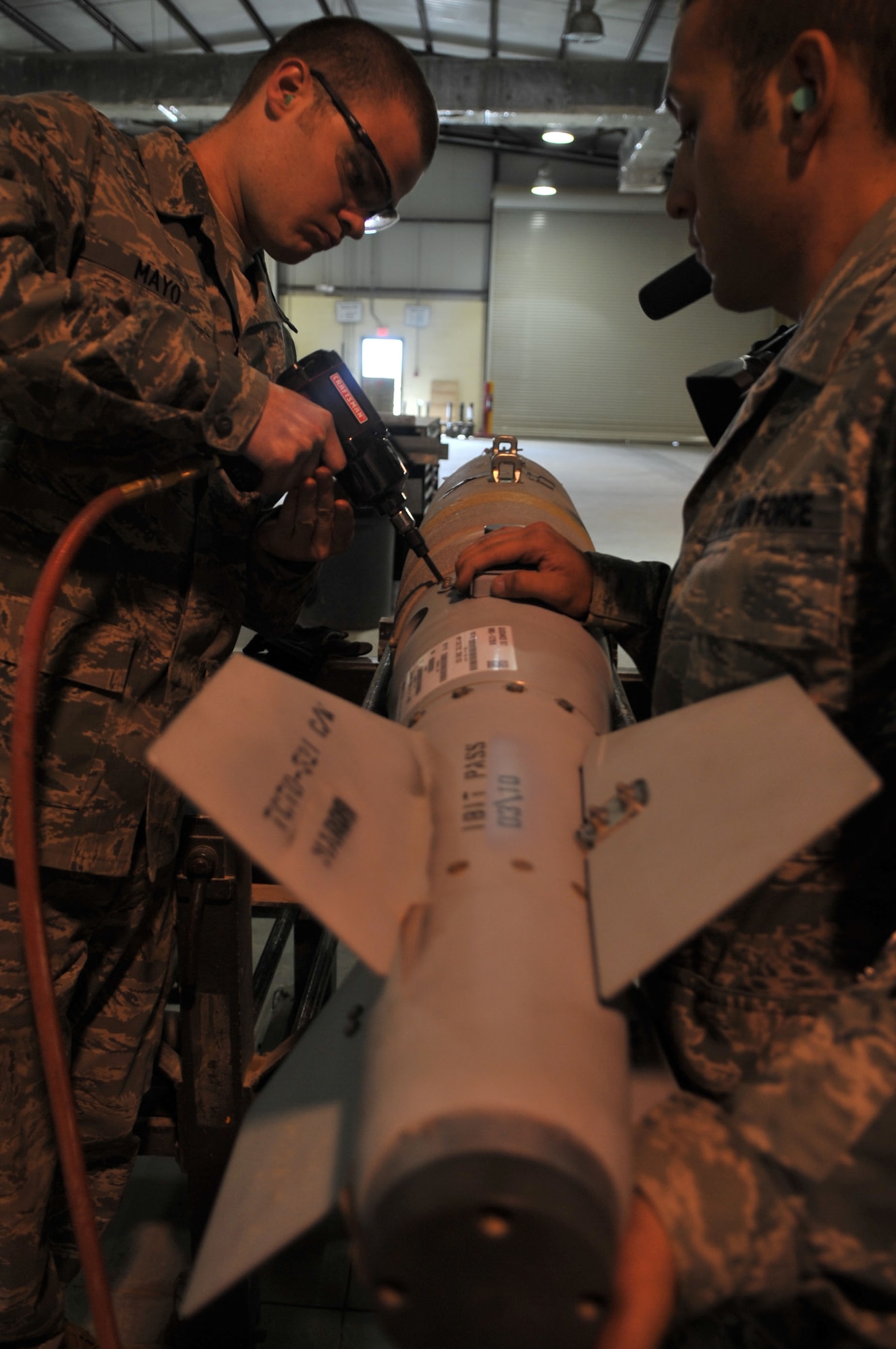 Staff Sgt. Phillip Mayo and Senior Airman Jamen Lomonaco, 332nd Expeditionary Maintenance Squadron munitions conventional maintenance crew members, install a fin on a GBU-38 Joint Direct Attack Munition at Joint Base Balad, Iraq, March 23, 2010. The 332nd EMXS provides full range intermediate maintenance on JBB aircraft by providing inspection, fabrication, accessories, armament, aerospace ground equipment and munitions capabilities. (U.S. Air Force photo/Senior Airman Brittany Y. Bateman/Released)