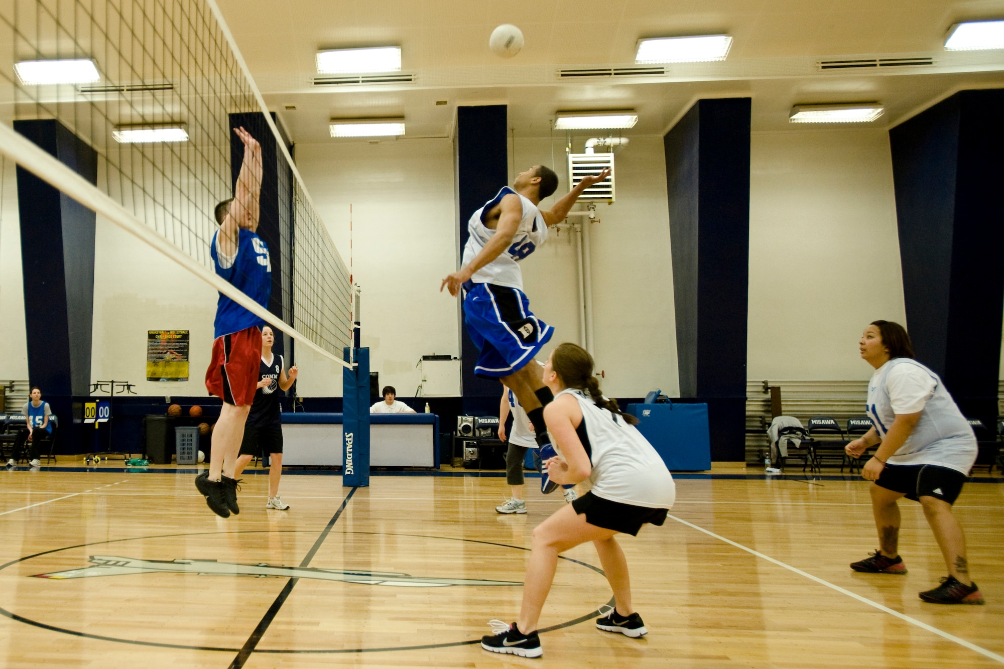 MISAWA AIR BASE, Japan -- Airman 1st Class Sydney Sullivan, of the 35th Force Support Squadron, readies a spike against Staff Sgt. Jeff Gall, of the 35th Communications Squadron, during an intramural volleyball game March 29 at the Potter Fitness Center. 35th FSS squeaked past 35th CS, winning two of the three sets played. (U.S. Air Force photo/Senior Airman Jamal D. Sutter)