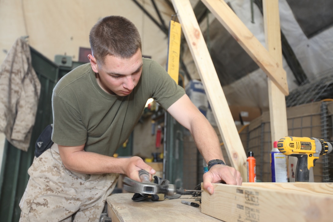 Lance Cpl. Thomas Hind, 25, from East Meadow, N.Y., works on building a pull-up bar at Camp Leatherneck, Afghanistan, March 30. Hind is a volunteer firefighter with the East Meadow Fire Department Ladder 1 and is currently on his first deployment to Afghanistan as a generator operator electrician from the Communications Maintenance Section, Headquarters and Service Company, 1st Marine Logistics Group (Forward).