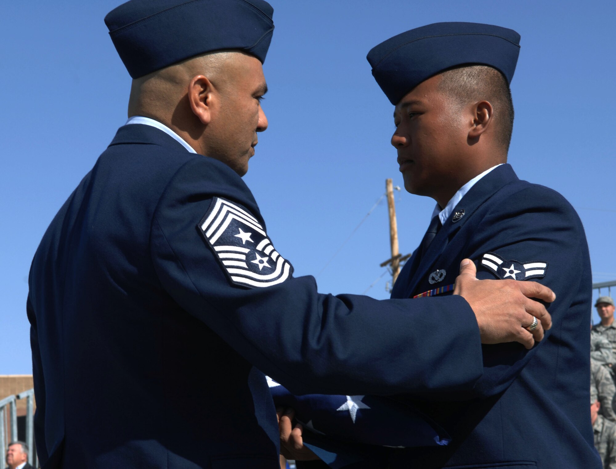 HOLLOMAN AIR FORCE BASE, N.M. -- Airman 1st Class Rawlinson Satulan, 49th Material Maintenance Squadron, receives a folded American flag from 49th Fighter Wing command chief, Chief Master Sgt. Gerardo Tapia during a Naturalization Ceremony, March 26, 2010 at Heritage Park. Airman Satulan, originally from the Philippines, has served in the U.S. Air Force since December 2008. Since September 2001, more than 53,000 U.S. armed forces members have been naturalized by the U.S. Citizenship and Immigration Services. (U.S. Air Force photo by Airman 1st Class Joshua Turner)(Released)
