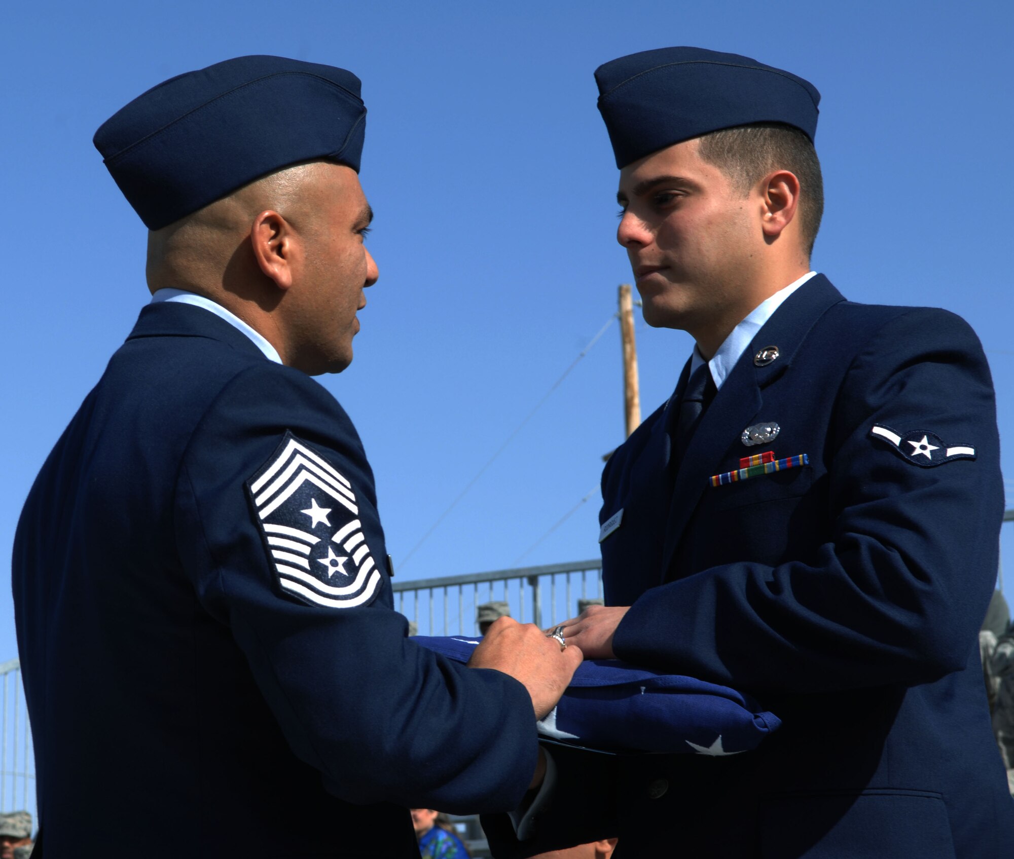 HOLLOMAN AIR FORCE BASE, N.M. -- Airman Juan Rodriguez, 49th Logistics Readiness Squadron, receives a folded American flag from 49th Fighter Wing command chief, Chief Master Sgt. Gerardo Tapia during a Naturalization Ceremony, March 26, 2010 at Heritage Park. Airman Rodriguez, originally from Ecuador, has served in the U.S. Air Force since July 2009. Since September 2001, more than 53,000 U.S. armed forces members have been naturalized by the U.S. Citizenship and Immigration Services. (U.S. Air Force photo by Airman 1st Class Joshua Turner)(Released)