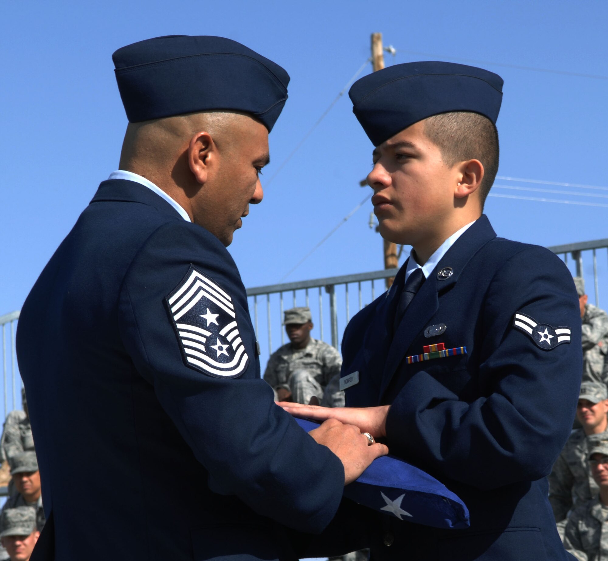 HOLLOMAN AIR FORCE BASE, N.M. -- Airman 1st Class Julian Monroy, 49th Operations Group, receives a folded American flag from 49th Fighter Wing command chief, Chief Master Sgt. Gerardo Tapia during a Naturalization Ceremony, March 26, 2010 at Heritage Park. Airman Monroy, originally from Colombia, has served in the U.S. Air Force since April 2009. Since September 2001, more than 53,000 U.S. armed forces members have been naturalized by the U.S. Citizenship and Immigration Services. (U.S. Air Force photo by Airman 1st Class Joshua Turner)(Released)
