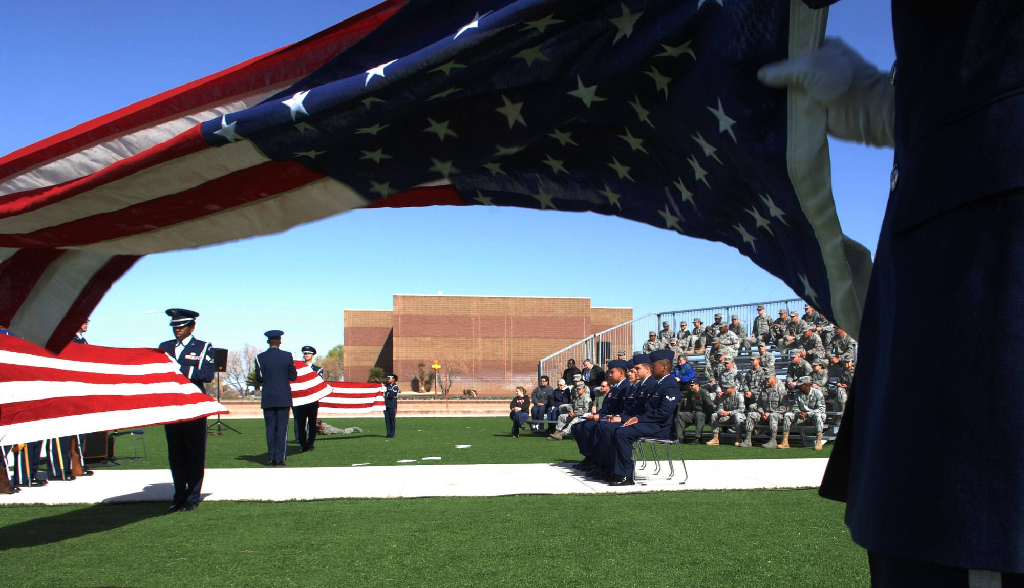 HOLLOMAN AIR FORCE BASE, N.M. -- Members of the Steel Talons Honor Guard fold U.S. flags to honor Airmen at a Naturalization Ceremony, March 26, 2010 at Heritage Park. Since September 2001, more than 53,000 U.S. armed forces members have been naturalized by the U.S. Citizenship and Immigration Services. (U.S. Air Force photo by Airman 1st Class Joshua Turner)(Released)