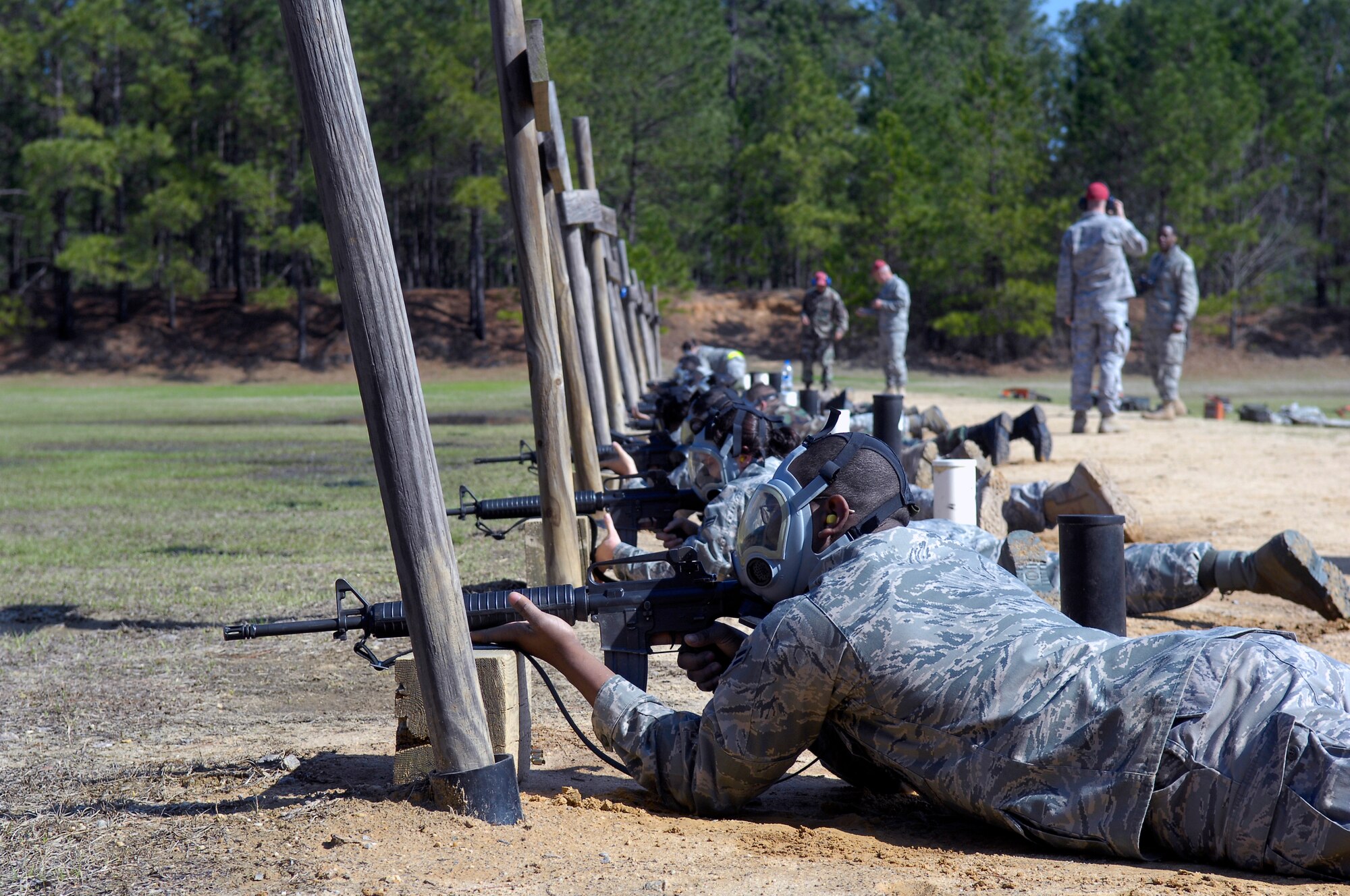 Combat Arms training course students line up in the prone-supported position in gas masks waiting for the order to fire at the firing range March 30. The students are re-qualifying on the M-16 and M-4 rifles in order to remain proficient for real world combat. (U.S. Air Force photo/Senior Airman Kris Levasseur)
