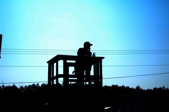 Staff Sgt. Daniel Ganus, 440th Security Forces Squadron Combat Arms Instructor, stands on top of the tower at the firing range overseeing the firing line during a remedial rifle skills class March 30. Sergeant Ganus is responsible for ensuring the safety of both instructors and students during the live fire training. (U.S. Air Force photo/Senior Airman Kris Levasseur)