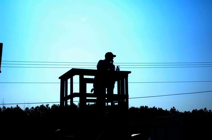 Staff Sgt. Daniel Ganus, 440th Security Forces Squadron Combat Arms Instructor, stands on top of the tower at the firing range overseeing the firing line during a remedial rifle skills class March 30. Sergeant Ganus is responsible for ensuring the safety of both instructors and students during the live fire training. (U.S. Air Force photo/Senior Airman Kris Levasseur)