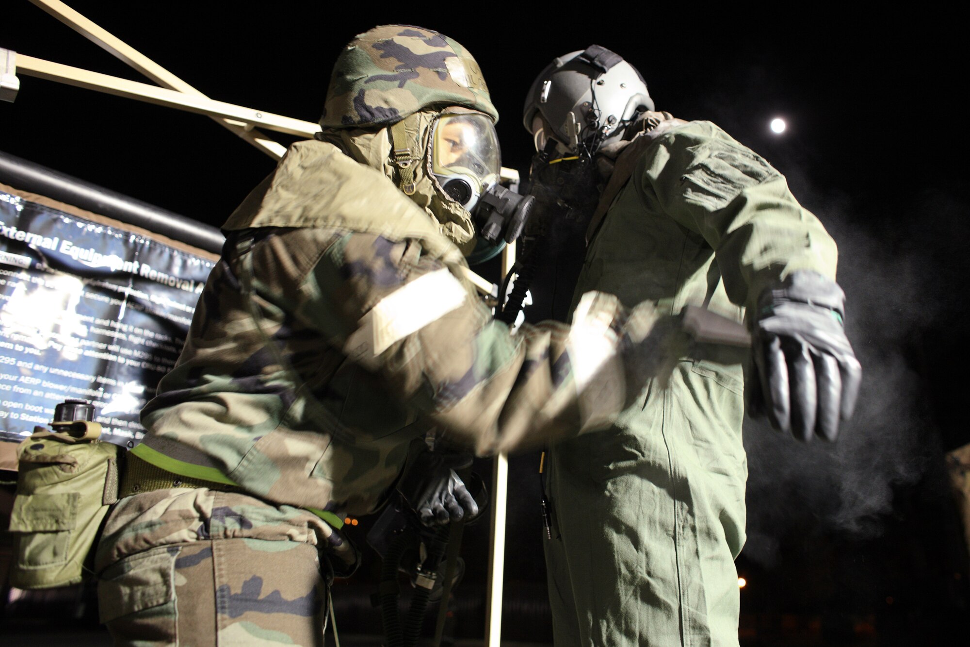 YOKOTA AIR BASE, Japan -- Airman 1st Class Robert Spear, 374th Operation Support Squadron, performs a chemical decontamination procedure on a simulated contaminated aircrew member here Apr. 1. Yokota conducted an exercise 28 Mar. through 1 Apr. to help maintain operational readiness.  (U.S. Air Force photo/Osakabe Yasuo)