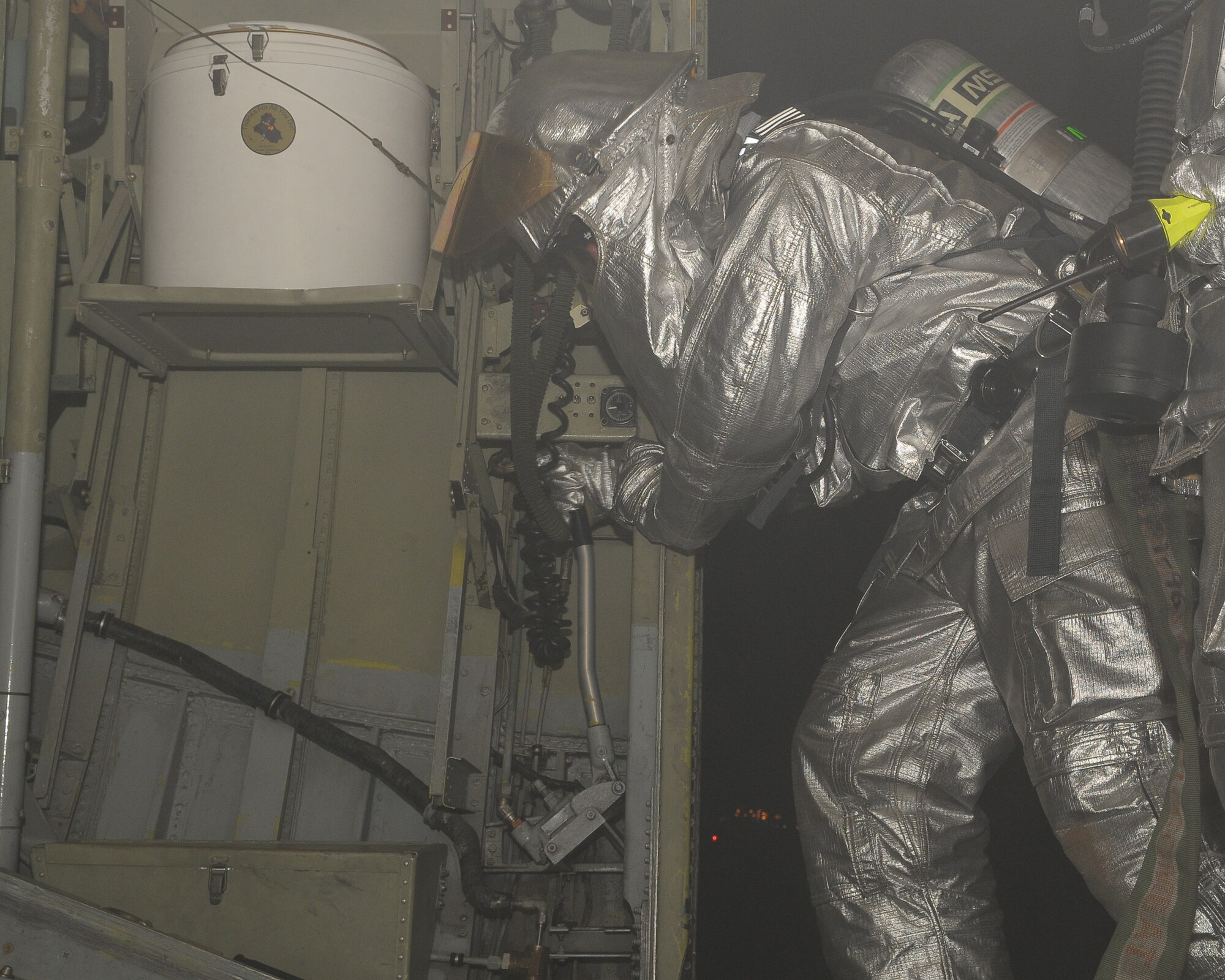 YOKOTA AIR BASE, Japan -- A firefighter from the 374th Civil Engineer Squadron opens the hatch of a C-130H Hercules during an egress Mar. 31. The hatch was opened to help clear out the smoke from a fire. (U.S. Air Force photo/Airman 1st Class Sean Martin)
