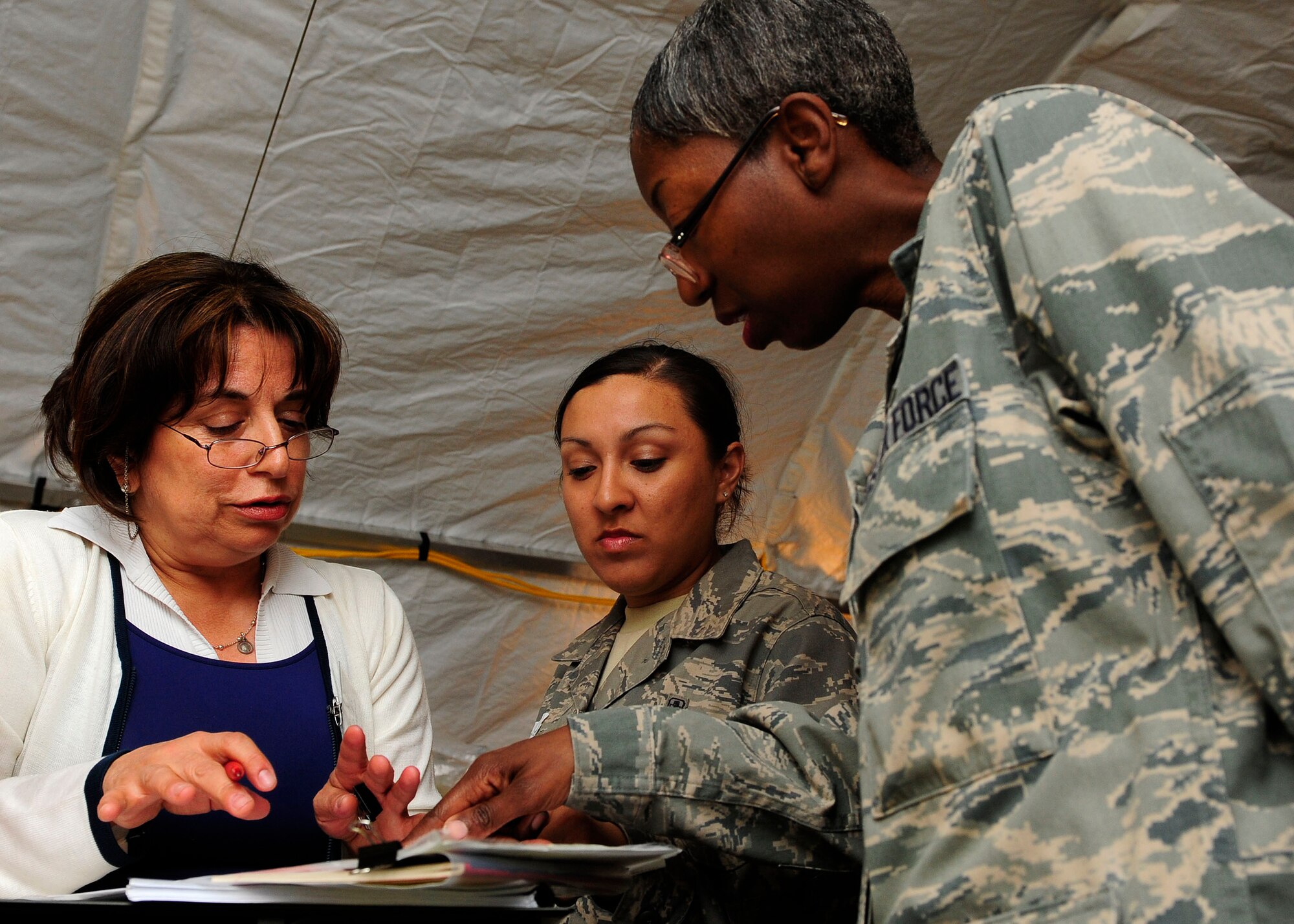 Airman Johnson translates a conversation between a Chilean nurse and Major Walker.  (U.S. Air Force photo by Senior Airman Tiffany Trojca)