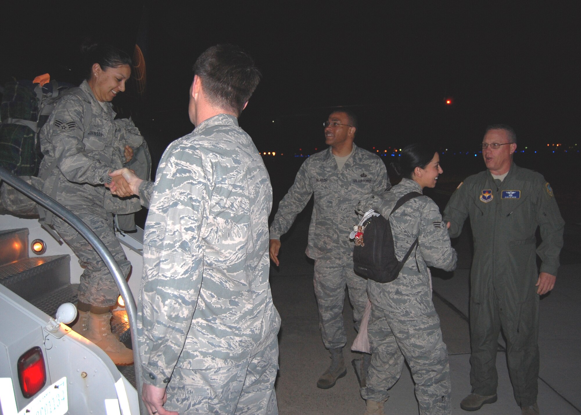 Senior Airmen Cassondra Johnson, left, 81st Aerospace Medicine Squadron, and Candice Cimball, 81st Medical Support Squadron, are welcomed back from their deployment to Chile about 2:30 a.m. Sunday by Brig. Gen. Ian Dickinson, 81st Training Wing commander; Chief Master Sgt. Lonnie Slater, 81st TRW command chief; and Brig. Gen. Dan Wyman, 81st Medical Group commander.  (U.S. Air Force photo by Stave Pivnick)