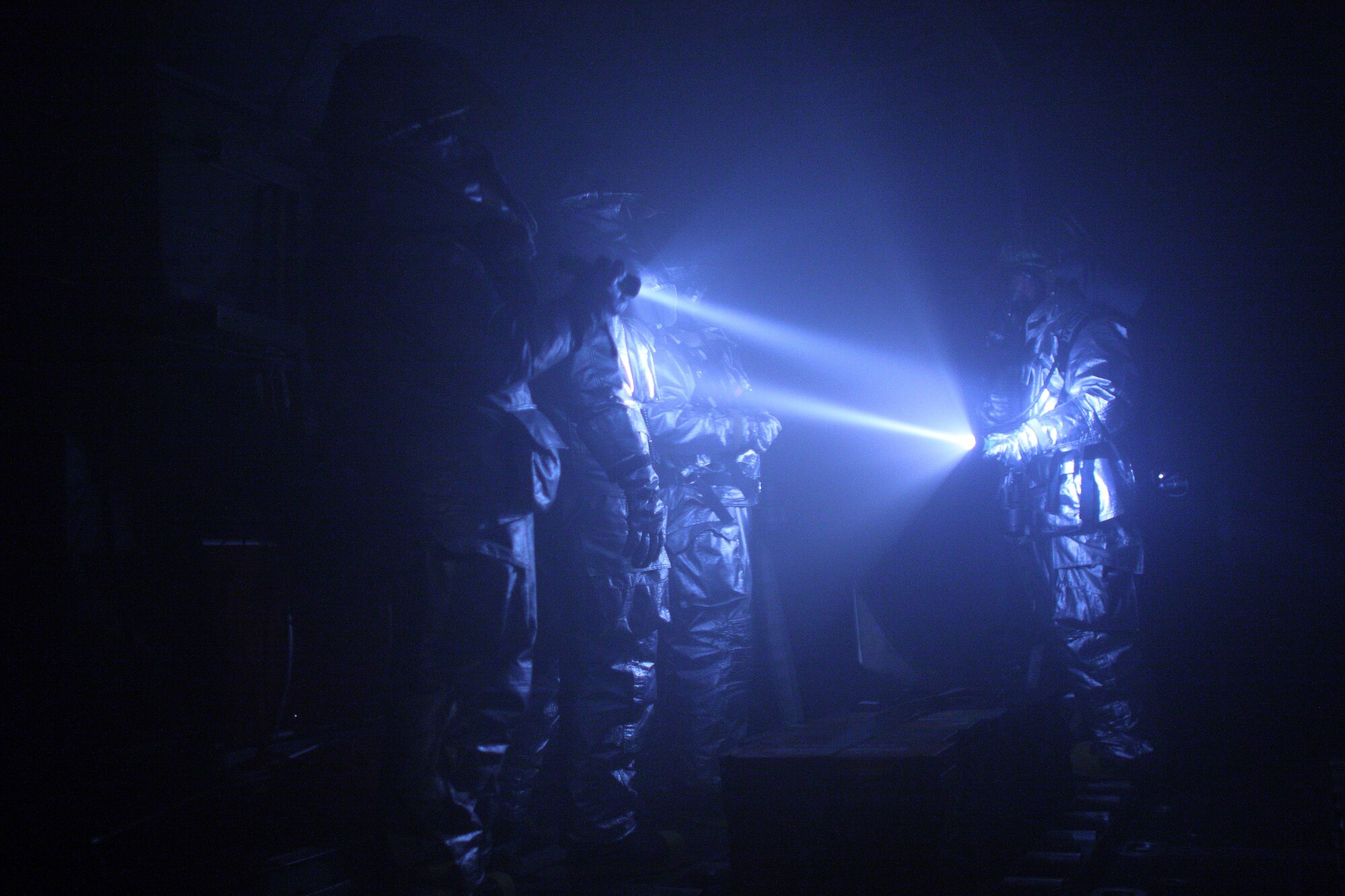 YOKOTA AIR BASE, Japan -- Firefighters from the 374th Civil Engineer Squadron searches a C-130H Hercules exit door due to a simulated fire on the flight deck here March 31. Yokota conducted an exercise 28 Mar. through 1 Apr. to help maintain operational readiness.  (U.S. Air Force photo/Osakabe Yasuo)