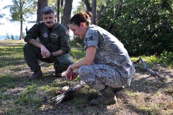 NAVAL AIR STATION KEY WEST, Fla. -- Air Force Reserve Master Sgt. Shawn Gardner, a loadmaster assigned to the 773rd Airlift Squadron, observes as Staff Sgt. Megan Kuszewski, assigned to the 439th Operational Support Squadron, demonstrates firecraft  or firestarting during a survival training course held here, February 21-22. Sergeant Gardner and a group of Citizen Airmen from the 910th Airlift Wing, based at Youngstown Air Reserve Station, Ohio attended the course to fulifill their annual requirement to refresh the skills needed in case their aircraft would go down over land or water. The coursework included segments covering map reading, compass use, food and water procurement, survival vest use, signaling and water survival training. U.S. Air Force photo by Master Sgt. Bob Barko Jr.  