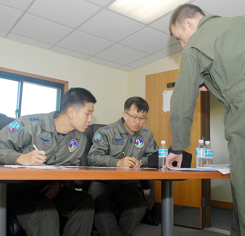 Maj. Crispin Kretzmann goes over the flight plan with South Korea air force Capt. Sung Jin Jeon and South Korea air force Maj. In Chang Jung during an exercise March 16, 2010, at Kunsan Air Base, South Korea. The exercise places U.S. and South Korea air force pilots together for several realistic aerial exercises to familiarize with each other's tactics and procedures. Major Kretzmann is assigned to the 391st Expeditionary Fighter Squadron. Captain Jeon and Major Chang are assigned to the 21st Fighter Squadron. (U.S. Air Force photo/Senior Airman Roy Lynch)