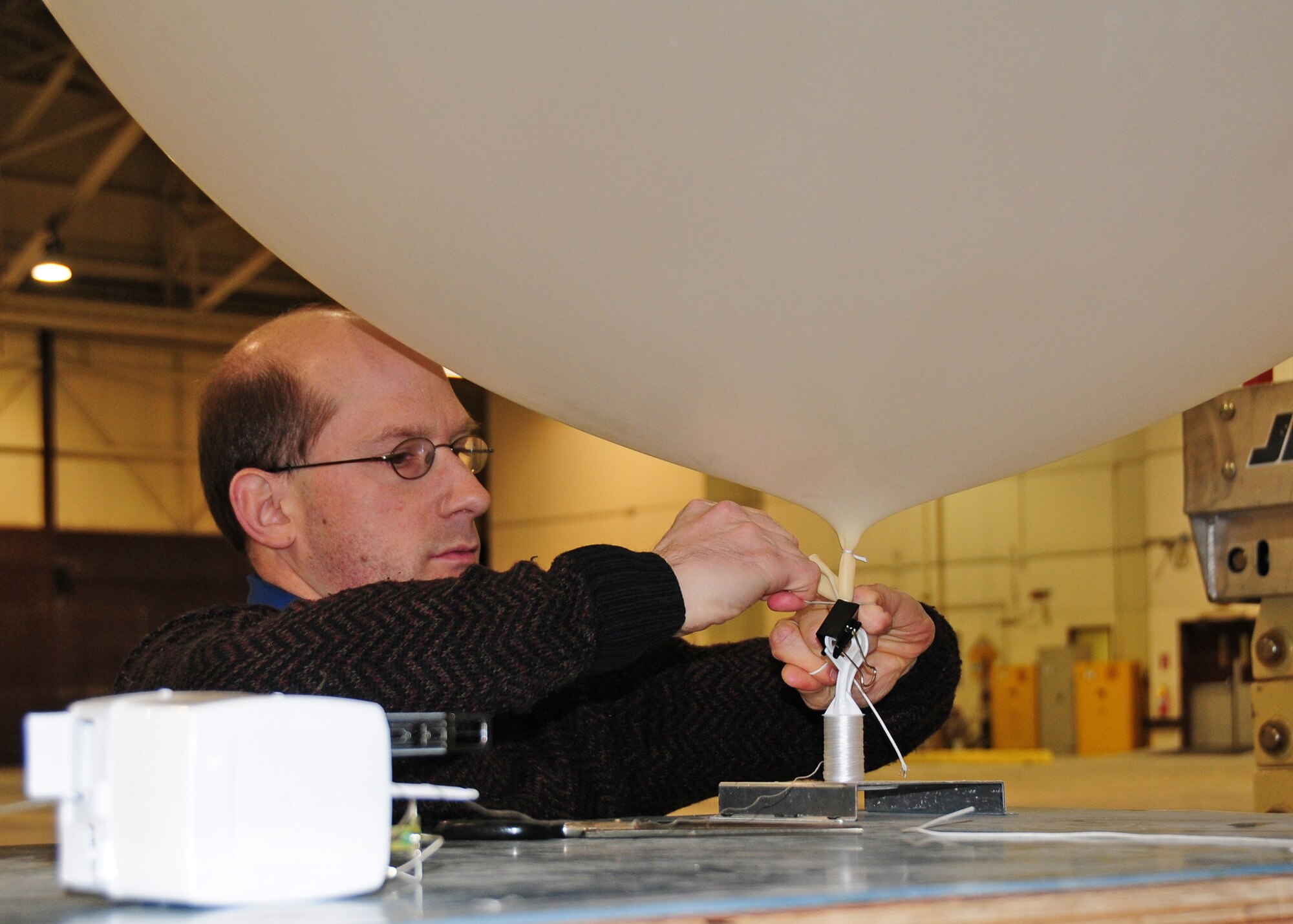 John Semanick, an information coordination center technician with Chugach McKinley Inc., Eareckson Air Station’s base operating support contractor, attaches a radiosonde to a weather balloon March 23. The radiosonde is a weather sensor used to collect temperature, winds aloft, pressure based on altitude and the dew point. (Air Force photo by Capt. Uriah Orland)