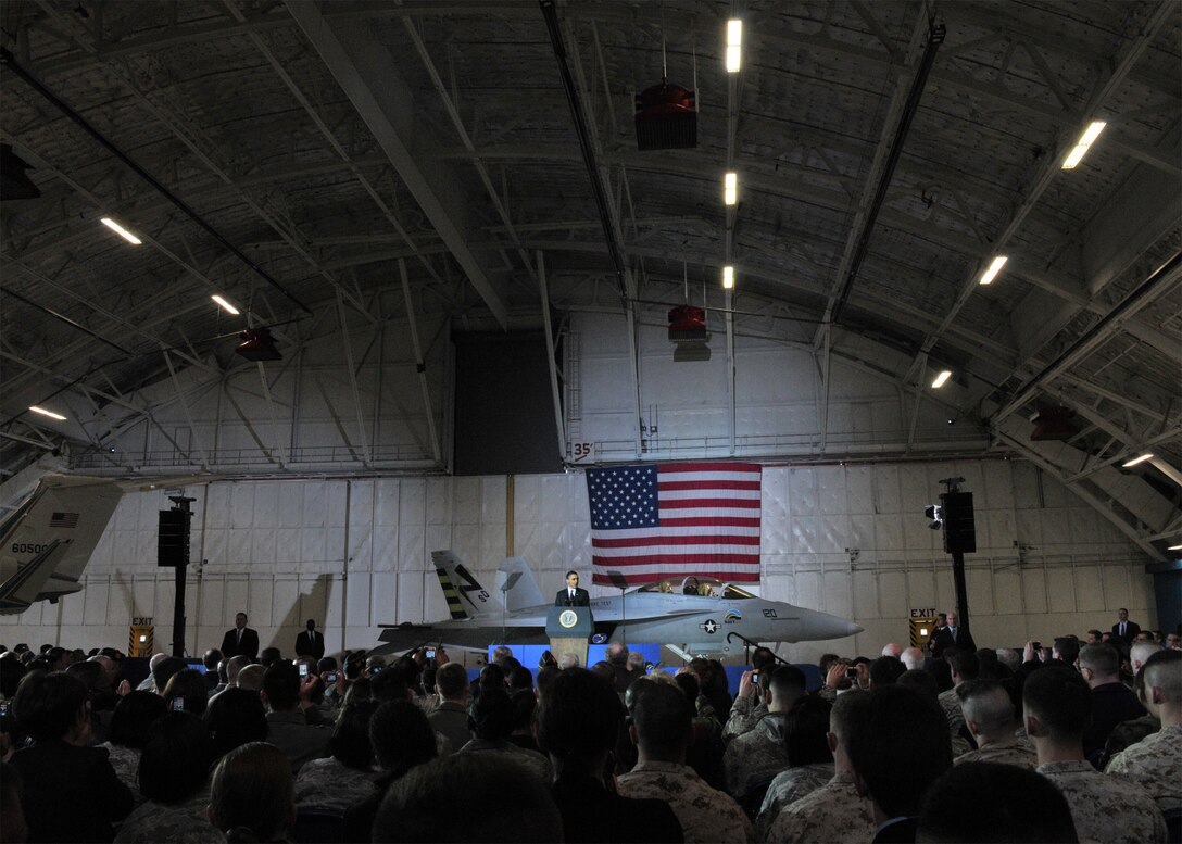 President Barack Obama speaks about a plan to lift a more than 20-year executive ban on offshore oil drilling to help reduce  America’s dependence on foreign oil as two Marines and a mix of service members and honorary guests look on in Hanger 3 at Joint Base Andrews, Md., March 31, 2010. He also discussed the use of bio fuels as an alternative fuel and that the Air Force is currently running tests on jet engines and achieved a successful bio fuel flight last week. (U.S. Air Force photo by Airman 1st Class Kat Lynn Justen)

