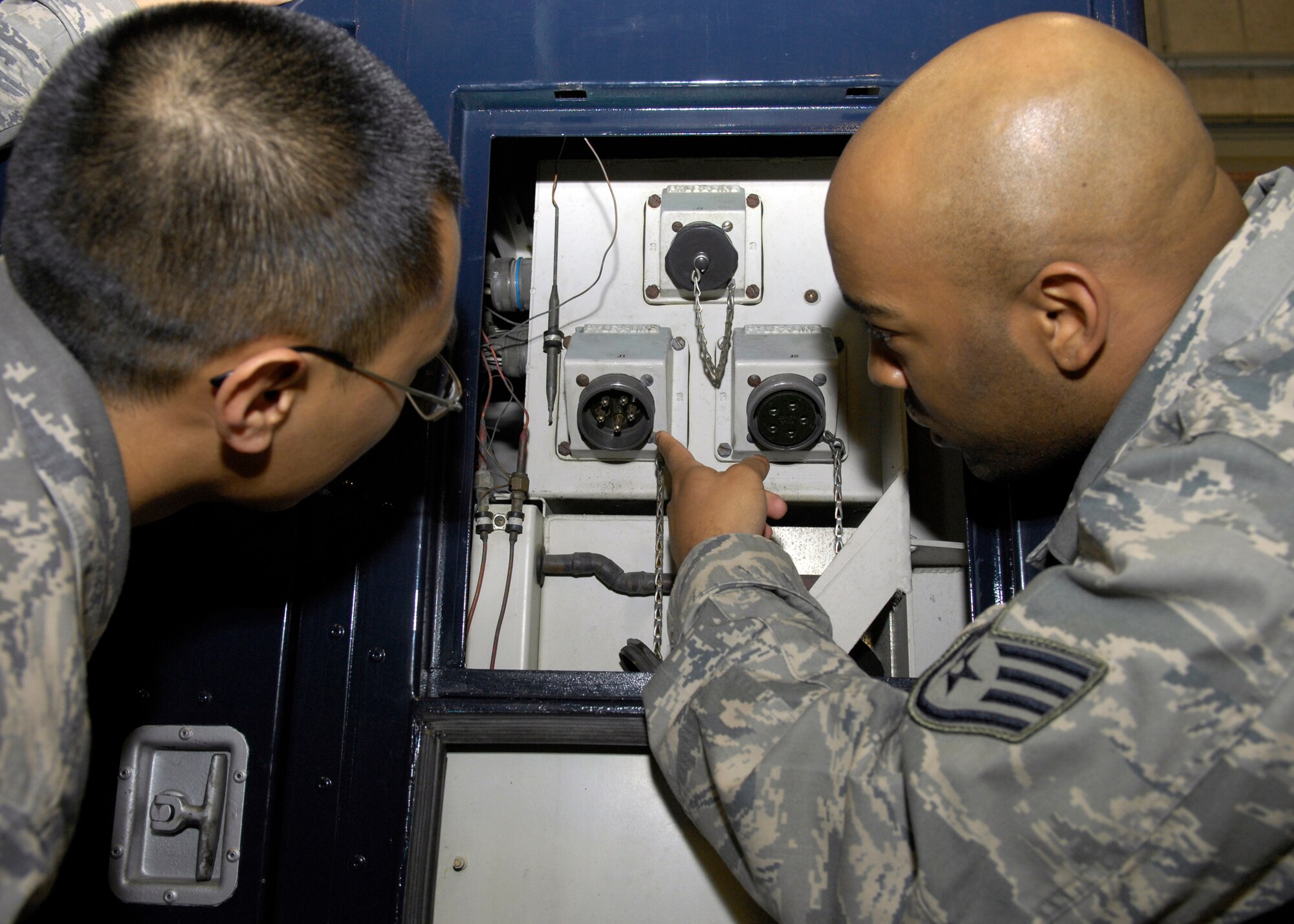 VANDENBERG AIR FORCE BASE, Calif. -- "There it is." Staff Sgt. Jayme Baucham, of the 576th Flight Test Squadron, points out a potential problem to Staff Sgt. Randy Nepomuceno, also with the 576th FLTS,  while working on the portable air conditioner here Thursday, March 11, 2010. Besides working on missile maintenance equipment the facility maintainers also conduct electrical and plumbing work for their squadron facilities. (U.S. Air Force photo/Airman 1st Class Lael Huss)