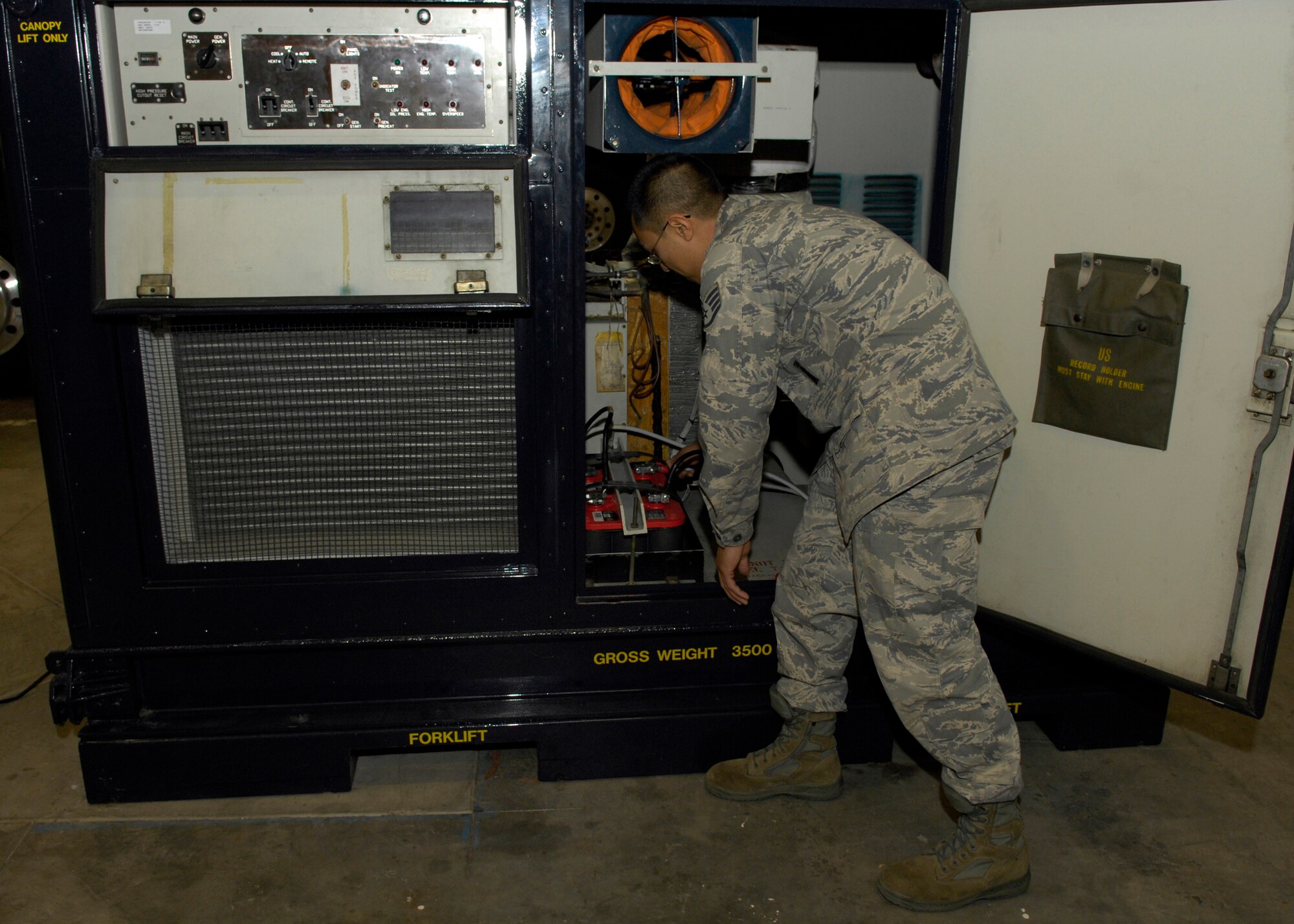 VANDENBERG AIR FORCE BASE, Calif. -- Replacing the battery cables, Staff Sgt. Randy Nepomuceno, of the 576th Flight Test Squadron, makes sure there is enough battery power to service the portable air conditioner while in field conditions here Thursday, March 11, 2010. What cannot be done in the confines of a bay is done in the field, thus the PAC is utilized when the missile is undergoing malfunctions and is in need of additional testing under cooler conditions. (U.S. Air Force photo/Airman 1st Class Lael Huss)