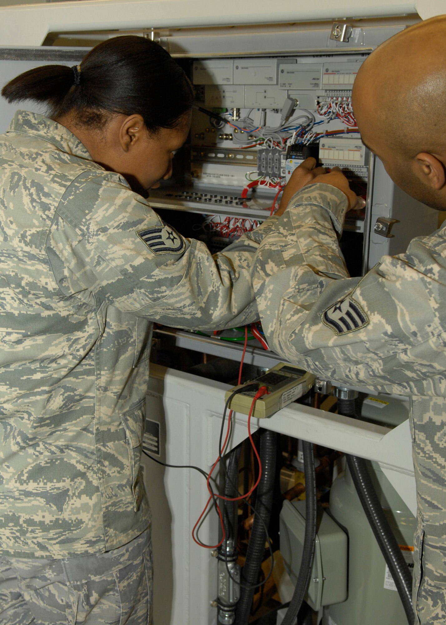 VANDENBERG AIR FORCE BASE, Calif. -- Showing correct placement of the ammeter, Staff Sgt. Jayme Baucham points Staff Sgt. Patricia Brown, both of the 576th Flight Test Squadron, to the correct quadrant inside the brine chiller here Thursday, March 11, 2010. The brine chiller keeps the environmental controls balanced on a missile during field inspections and must be tested to ensure it is in proper working order before use. (U.S. Air Force photo/Airman 1st Class Lael Huss)